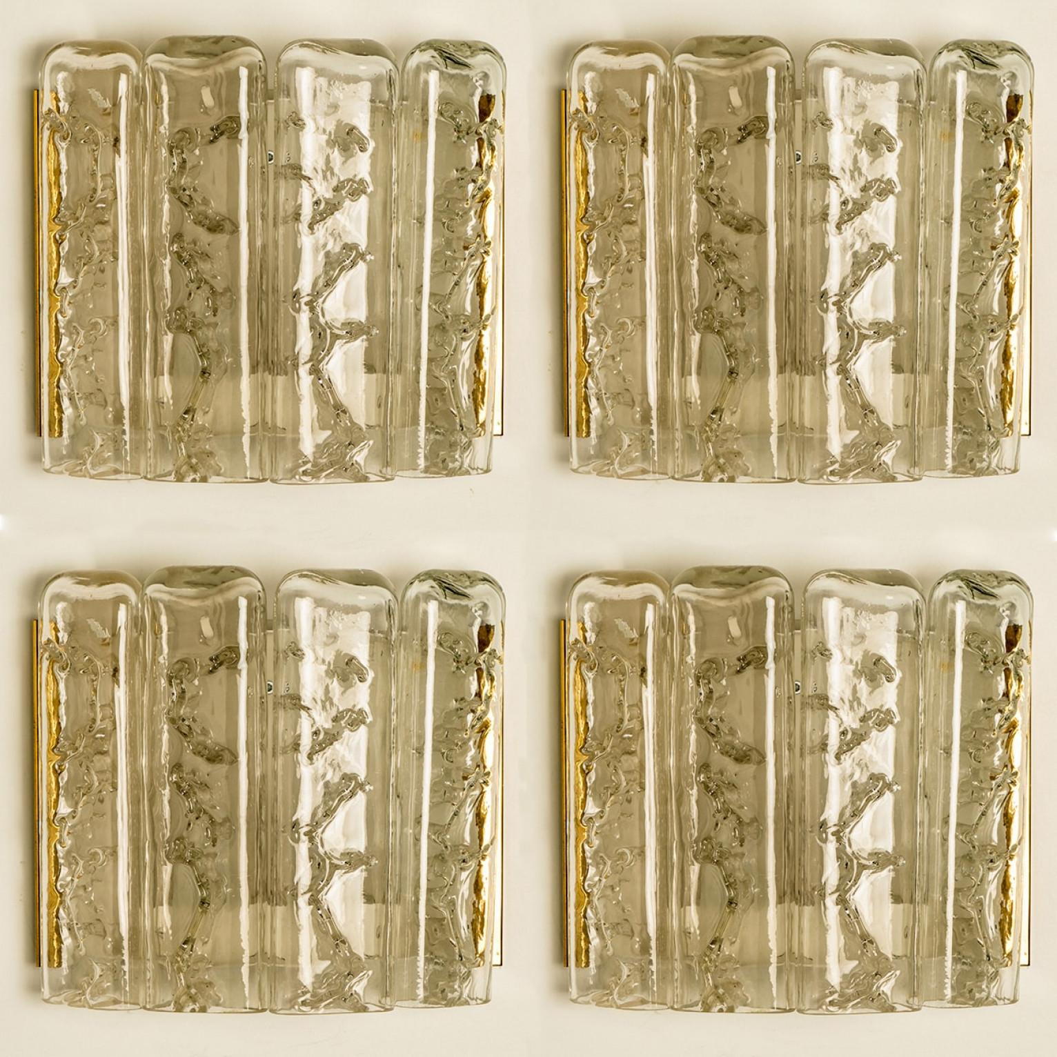 1 of the 5 blown wall sconces date from the 1960s and were created by the iconic firm of Doria Leuchten in Germany. They are fabricated with a back plate in white and brass and with four molten-glass, flat tubular prisms. High-end pieces.

H 8.27