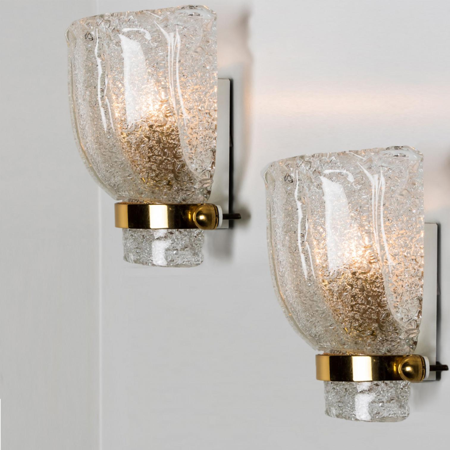 Clean lines to complement all decors. A wonderful high-end Hillebrand wall light fixture with brass detail and thick tulip shaped ice glass. The ice glass refracts the light beautifully, filling a room with a soft, warm glow.

The wall sconce has a