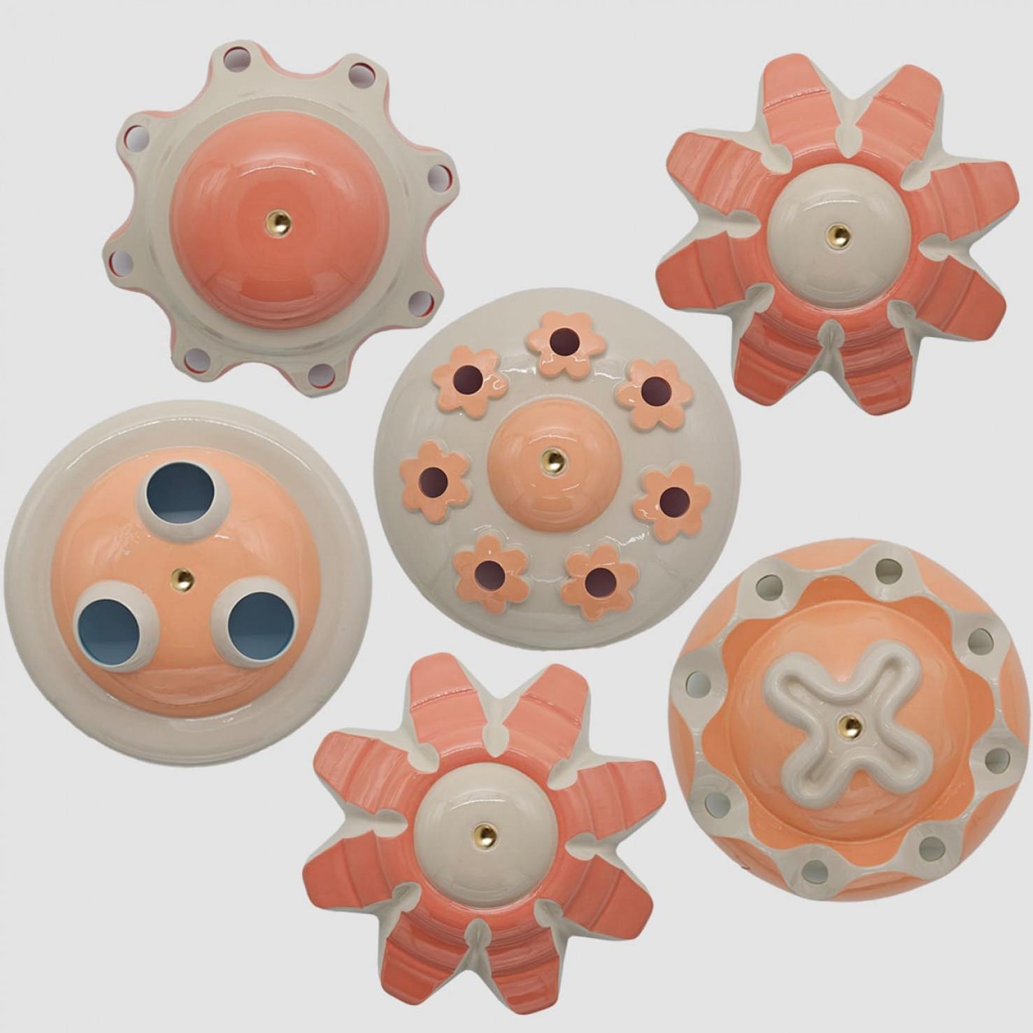 Unique hand-cast ceramic “rosettes” from Jeanine Keizer’s 1990s Lichtpuntje installation are reborn as sculptural pendant lamps. Each set groups five to seven pieces in harmonising colours, creating a gentle, child-friendly glow. The biomorphic