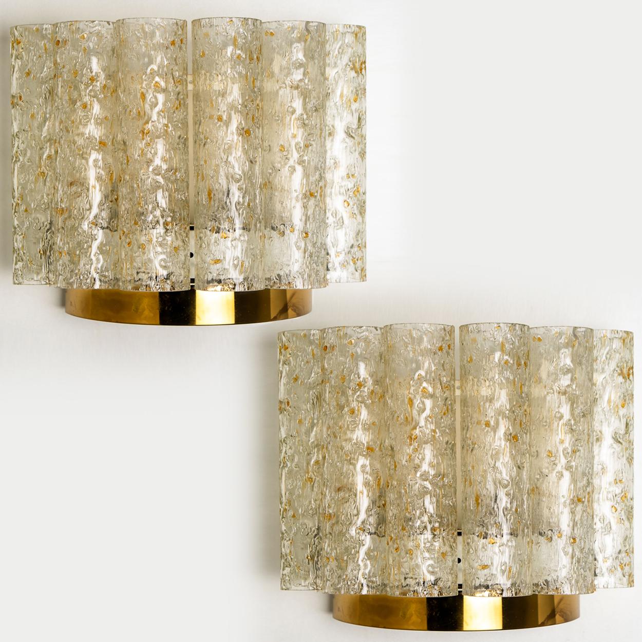 Wunderschönes Set aus mundgeblasenen Doria-Wandlampen. Hergestellt in den 1960er Jahren. Mit strukturierten, klaren und bernsteinfarbenen Glaspfeifen mit Sprenkeln
Die stilvolle Eleganz dieser Lampe passt zu vielen Umgebungen, von der Mitte des