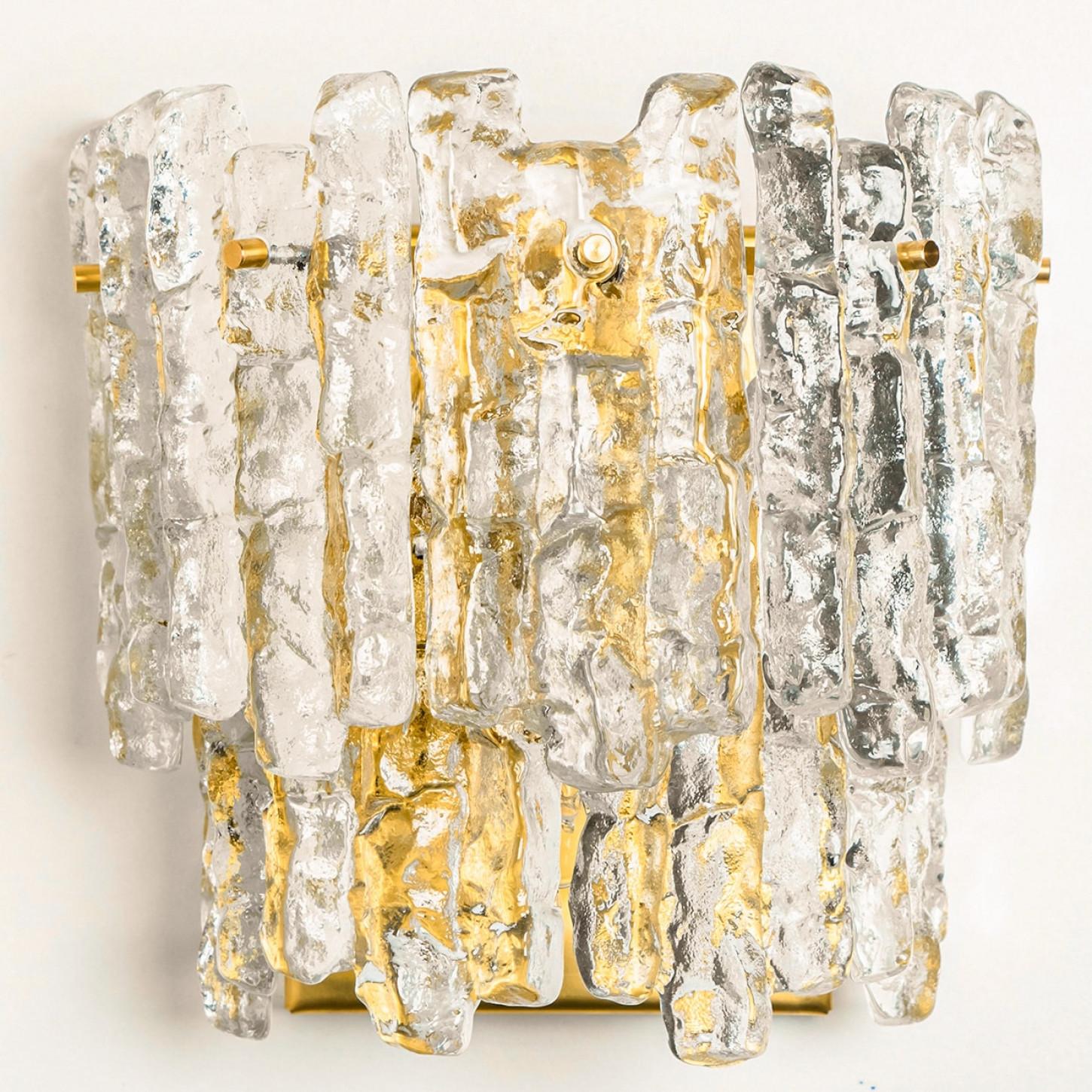 Beautiful high quality light fixture made by Kalmar, Austria. Manufactured in mid century, circa 1970 (at the end of 1960s and beginning of 1970s).

This XL wall light features lights made of handmade ice glass and brass back plate. The sides