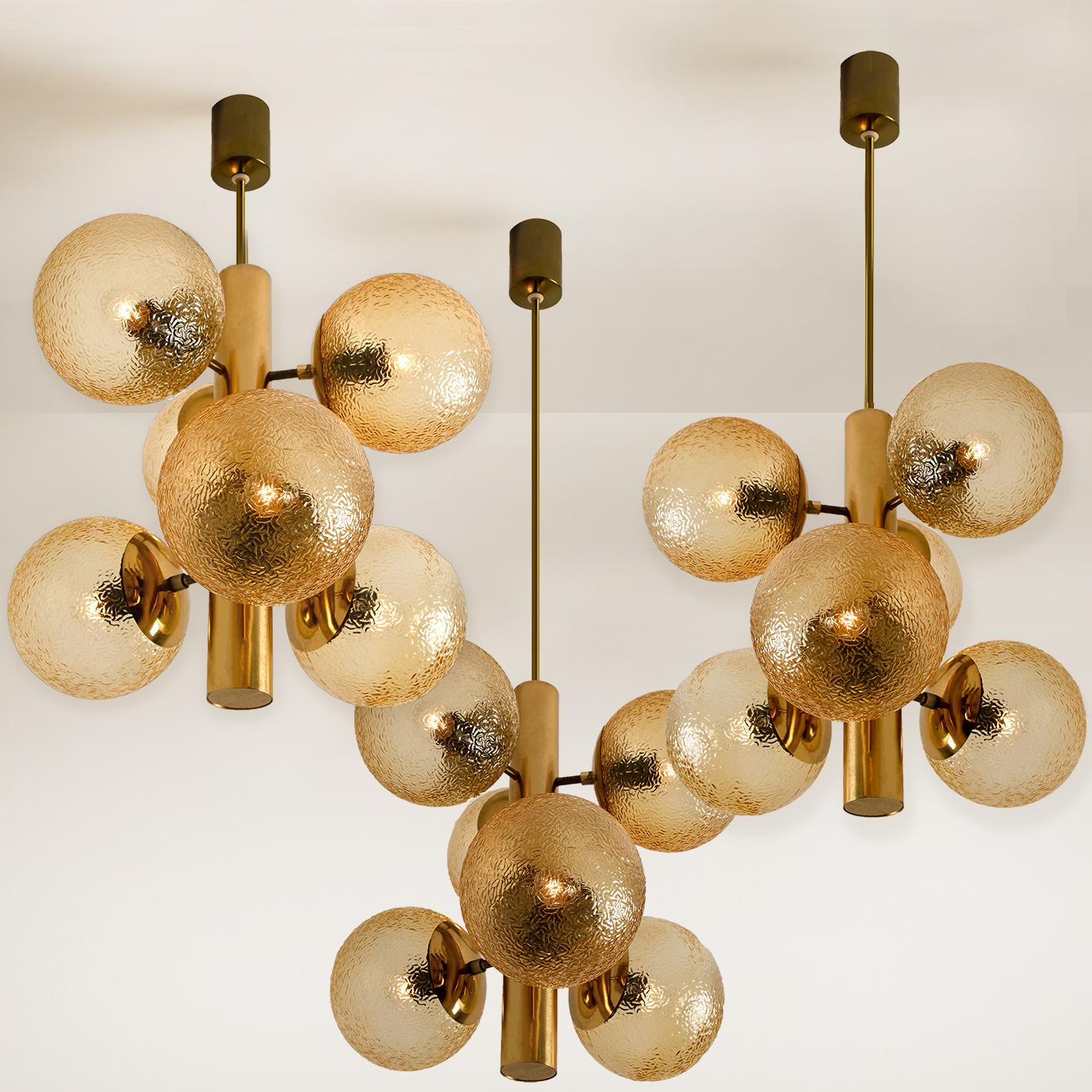1 of the 7 gorgeous chandeliers with a molecular structure, a brass central body is surround by 6 attached globes with amber glass. Illuminates beautifully. Manufactured in midcentury, circa 1970 (at the end of 1960s and beginning of 1970s).

This