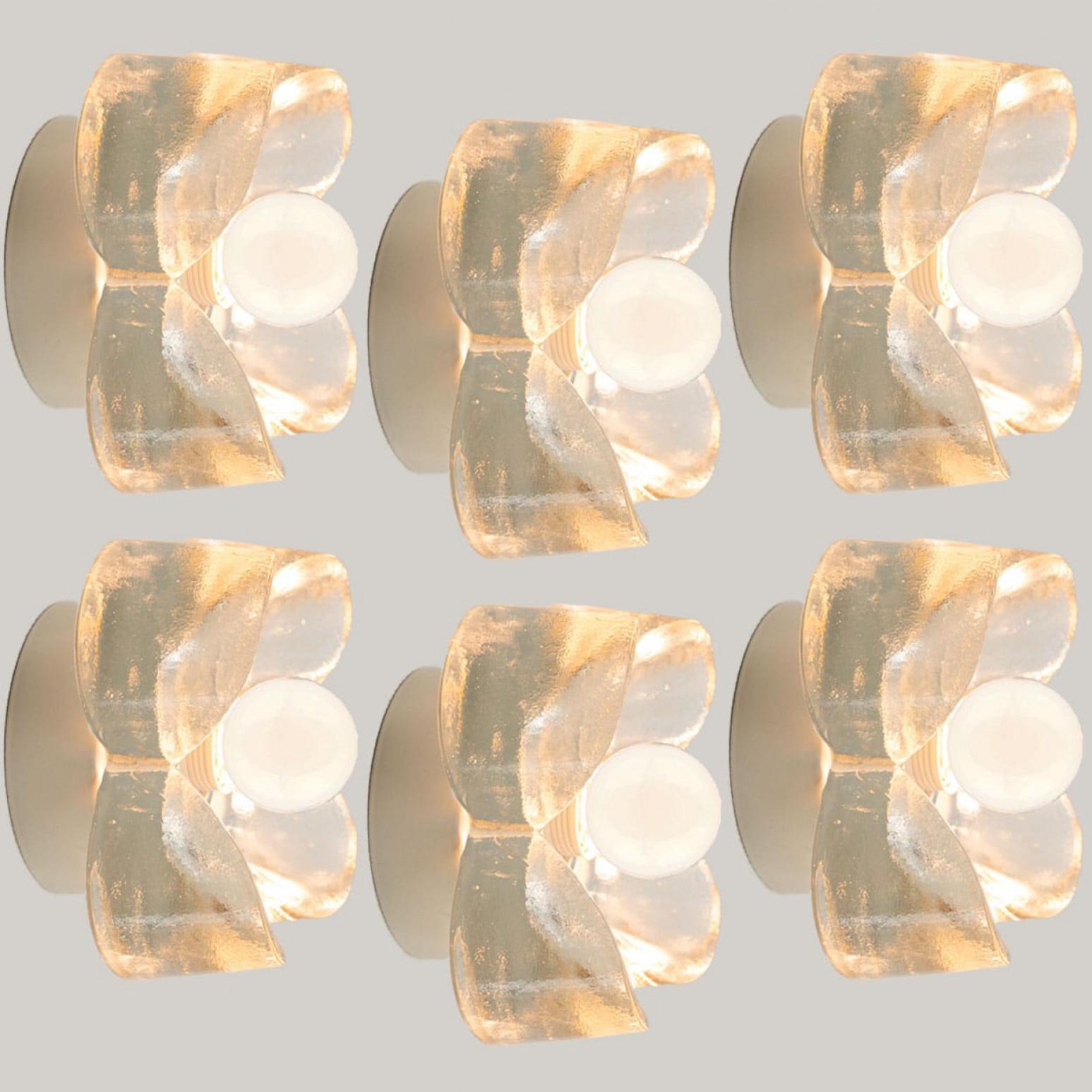 
Paire d'appliques/encastrés à fleurs en verre bullé sur une monture ronde en métal blanc, vers les années 1970, Allemagne. Un design clair, avec des matériaux modernes.

Ce design moderniste et élégant se concentre sur le verre épais en forme de