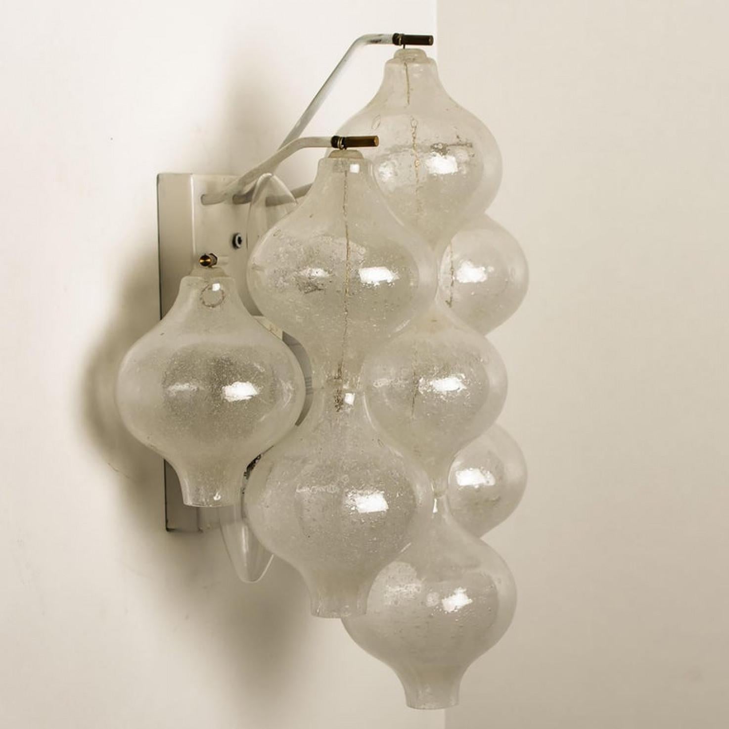 1 of the 8 unique elegant 'Tulipan' glass wall sconces by J.T. Kalmar, Austria, Vienna, manufactured in midcentury, circa 1970 (late 1960s-early 1970s). With tulip shaped hand blown bubble glasses. With a white enameled metal frame which holds 9