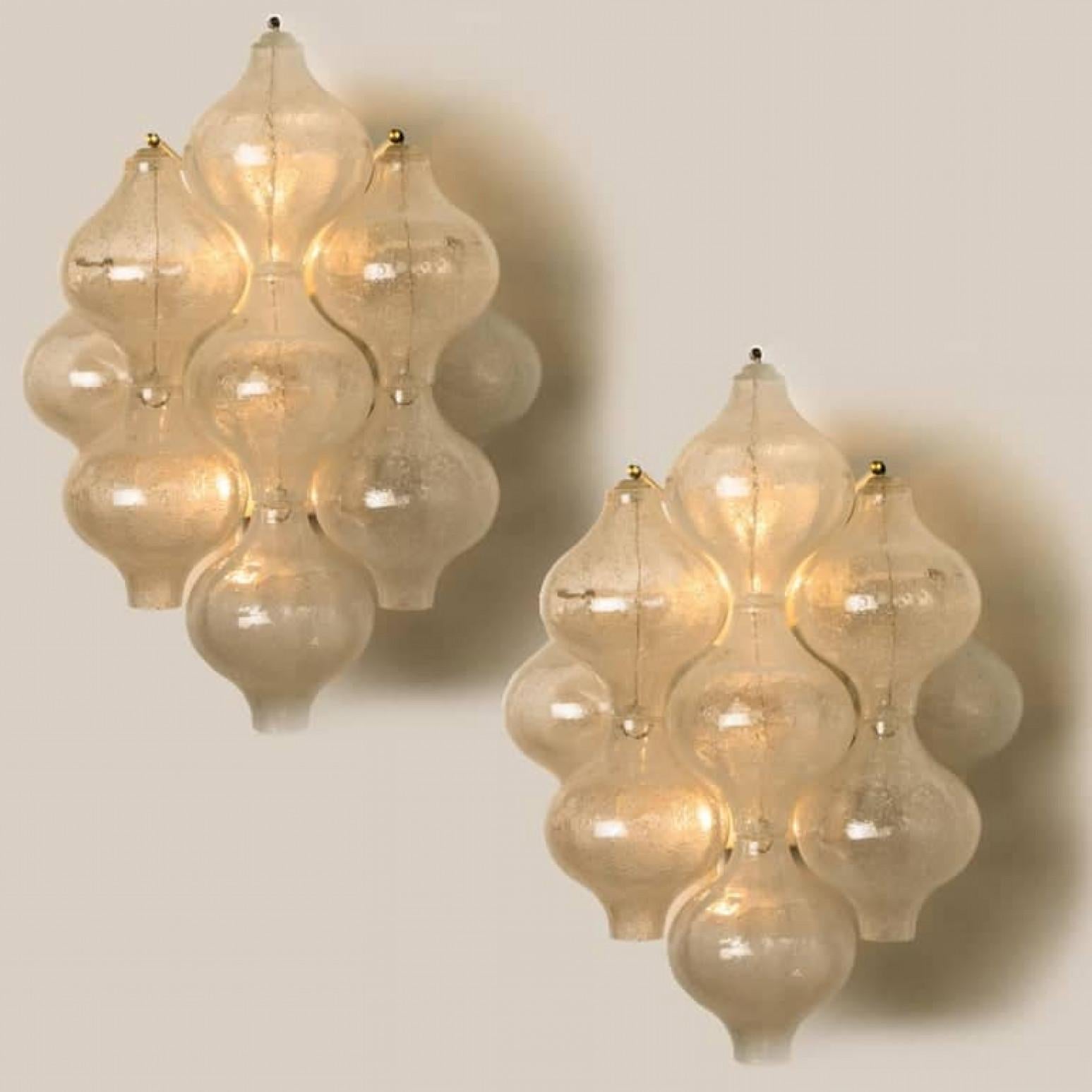 1 of the 8 unique elegant 'Tulipan' glass wall sconces by J.T. Kalmar, Austria, Vienna, manufactured in midcentury, circa 1970 (late 1960s-early 1970s). With tulip shaped hand blown bubble glasses. With a white enameled metal frame which holds 9