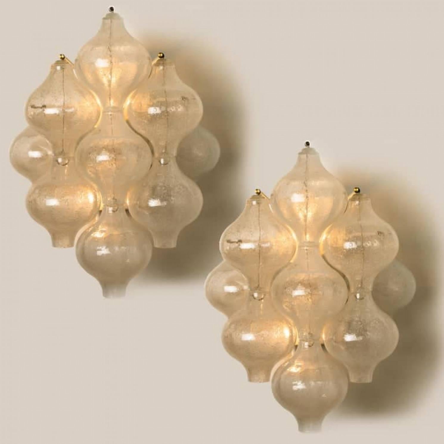 1 of the 8 unique elegant 'Tulipan' glass wall sconces by J.T. Kalmar, Austria, Vienna, manufactured in midcentury, circa 1970 (late 1960s-early 1970s). With tulip shaped hand blown bubble glasses. With a white enameled metal frame which holds 9