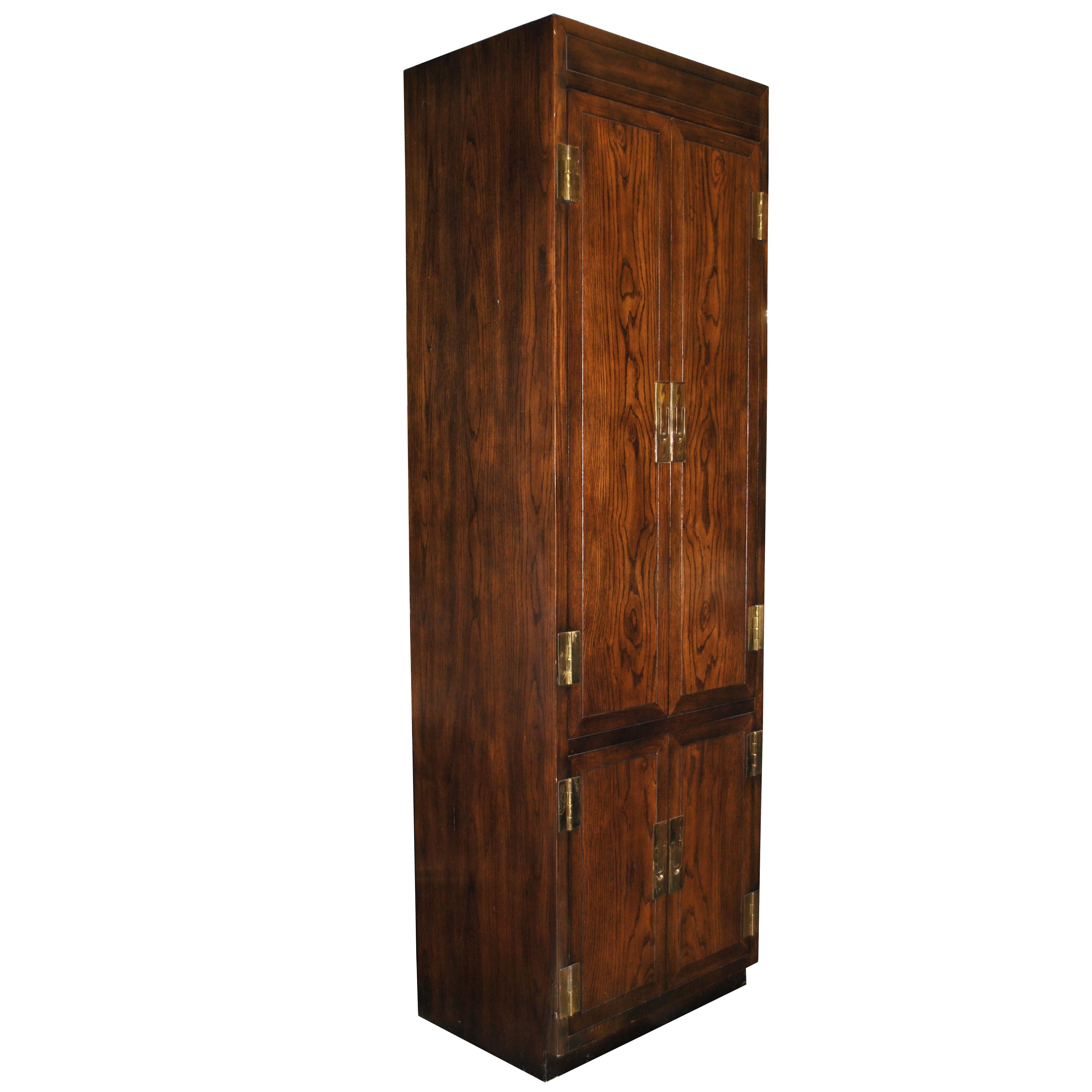 Campaign style armoire by Henredon from the Scene One collection

Dark walnut with brass hinges and latch pulls.

Dovetailed drawers and shelves. Manufacturer's mark.

    