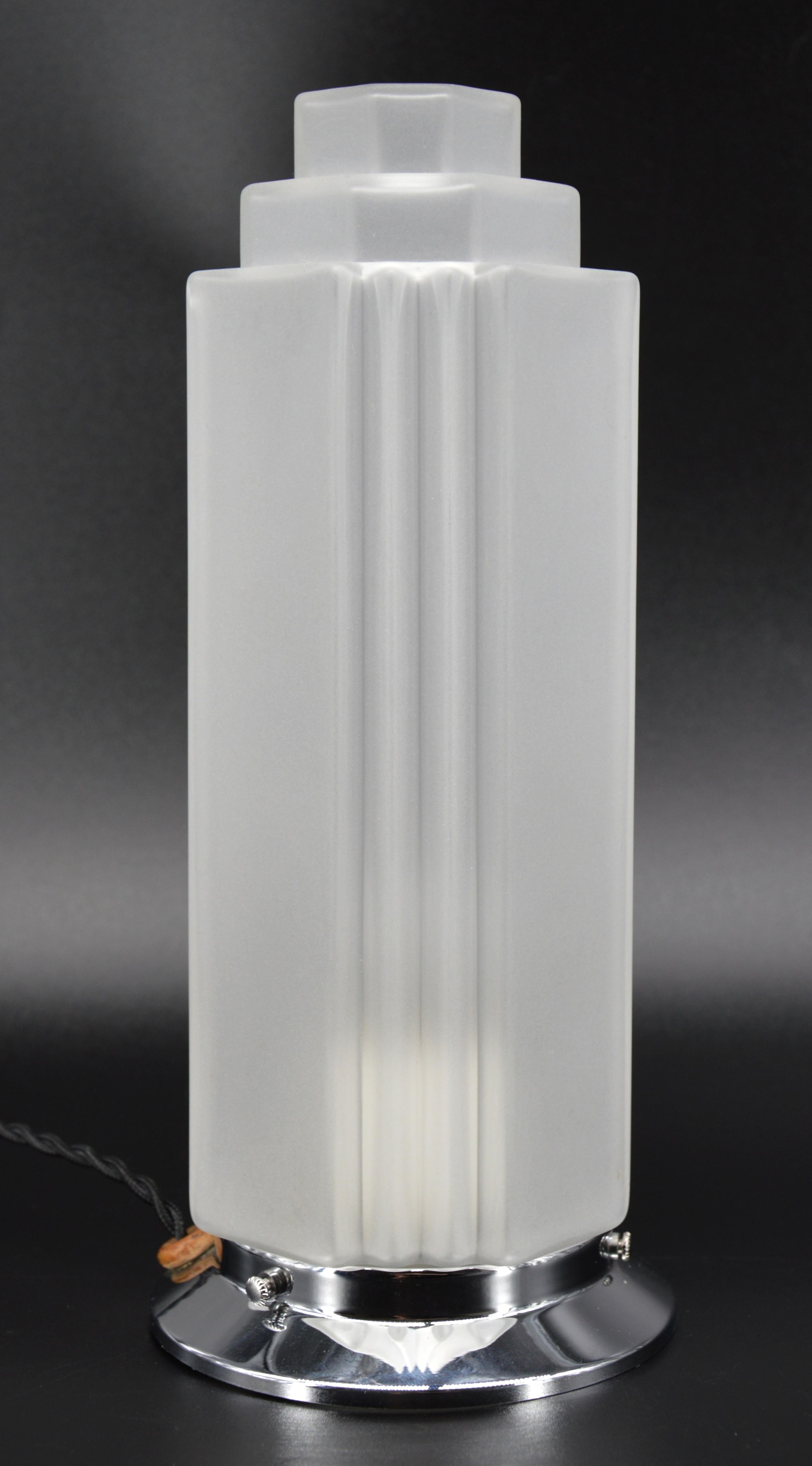 Lampe de table Art déco française, France, années 1930. Forme de gratte-ciel. Abat-jour en verre dépoli sur sa base chromée. 3 lampes sont disponibles. Hauteur : 26,8 cm (10,6