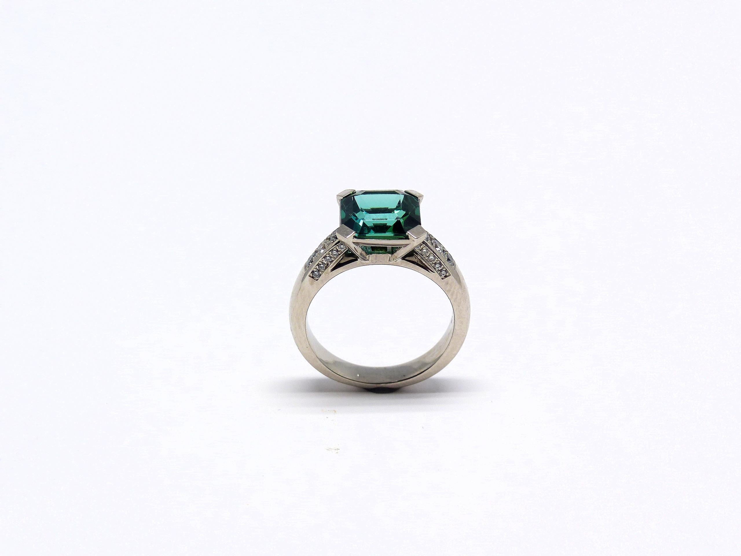 Thomas Leyser ist bekannt für seine zeitgenössischen Schmuckentwürfe unter Verwendung edler Edelsteine. 

Dieser Ring aus 18-karätigem Weißgold (8,30 g) ist mit 1x feinem, intensiv grün-blauem Turmalin (facettiert, 9x9 mm, 3,20ct) + 26x Diamanten