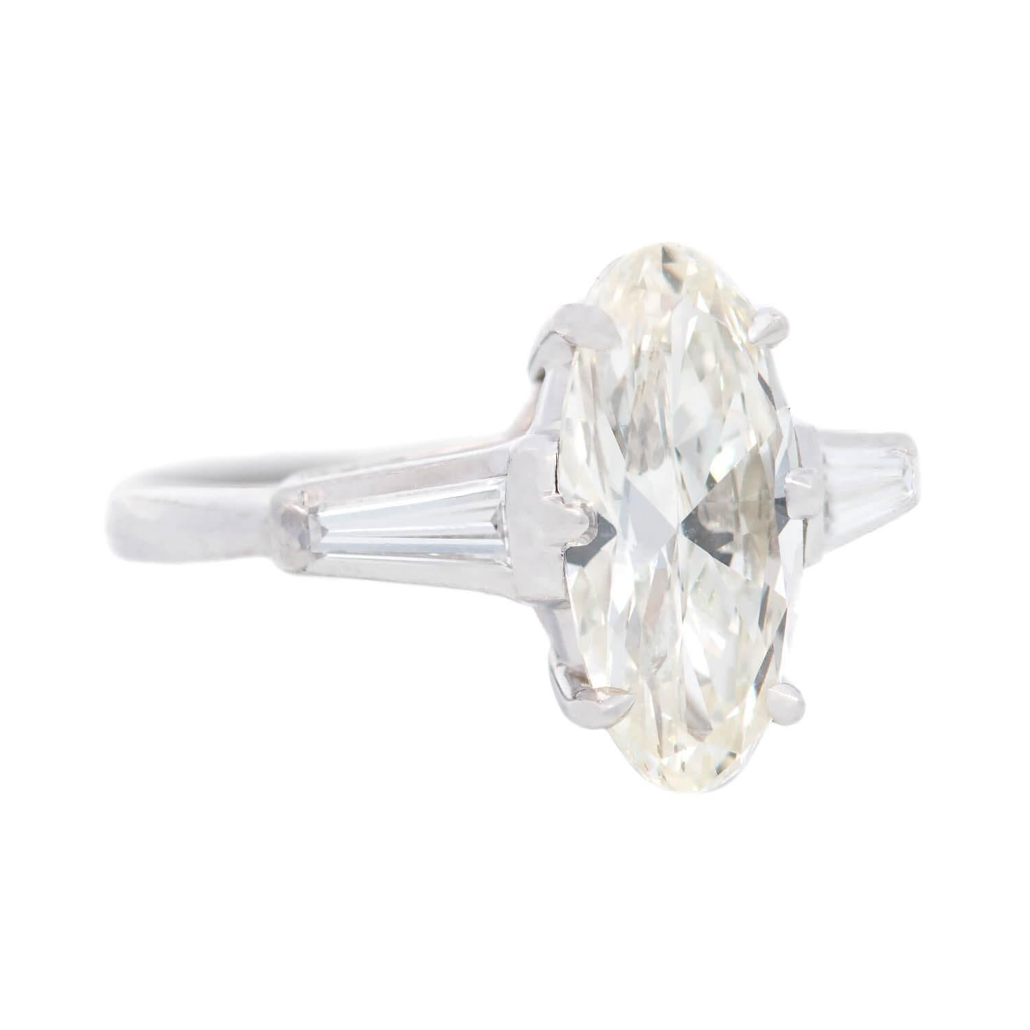 A simply outstanding diamond engagement ring from the Vintage (ca1960) era! This beautiful piece is crafted in platinum and holds a gorgeous moval cut, a type of modified marquise cut, diamond at the center. The diamond, which is prong set, has J/K