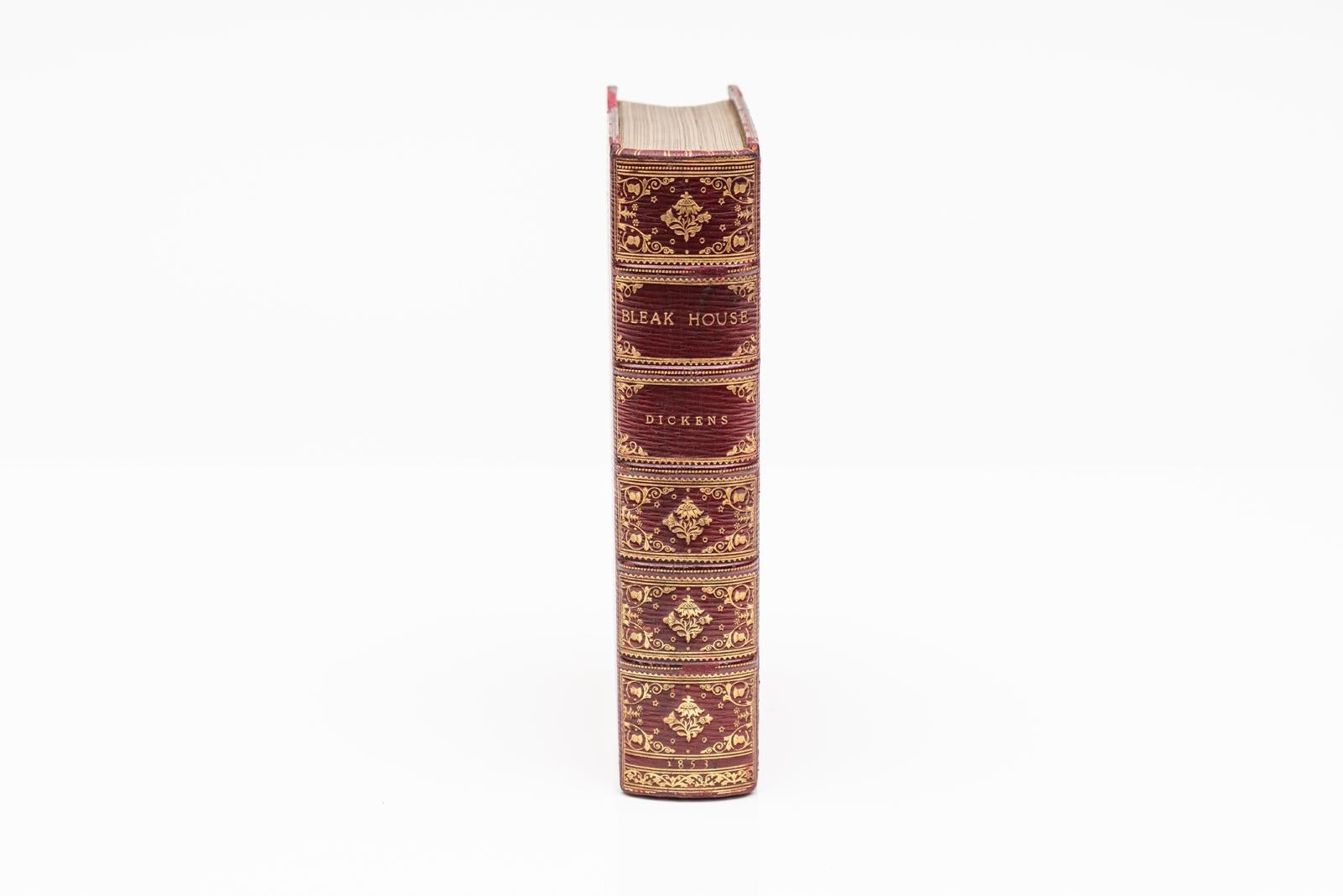 1 Vol. Charles Dickens, Casa desolada. Primera edición. Ilustrado por H.K. Browne. Encuadernado en pleno Marruecos rojo. Todos los bordes dorados. Bordes dorados en el interior y el exterior de las cubiertas. Paneles dorados ornamentados en el lomo.