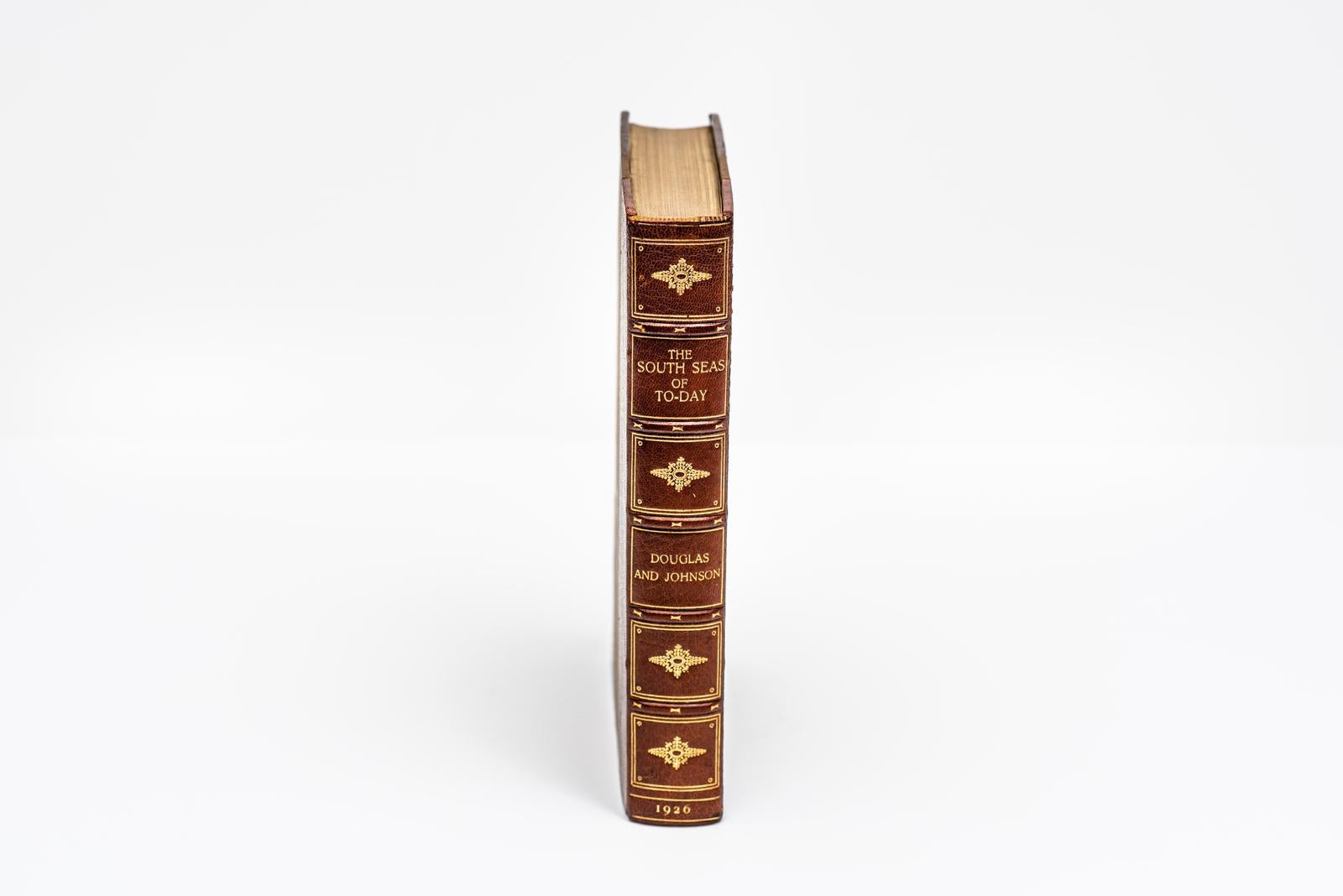1 Volume. A.J.A. Douglas & P.H. Johnson, The South Seas of Today. Bound by Bayntun in 3/4 brown morocco and linen boards. The covers and raised band spine are decorated in gilt-tooling. The top edge is gilt with marbled endpapers. 39 illustrations
