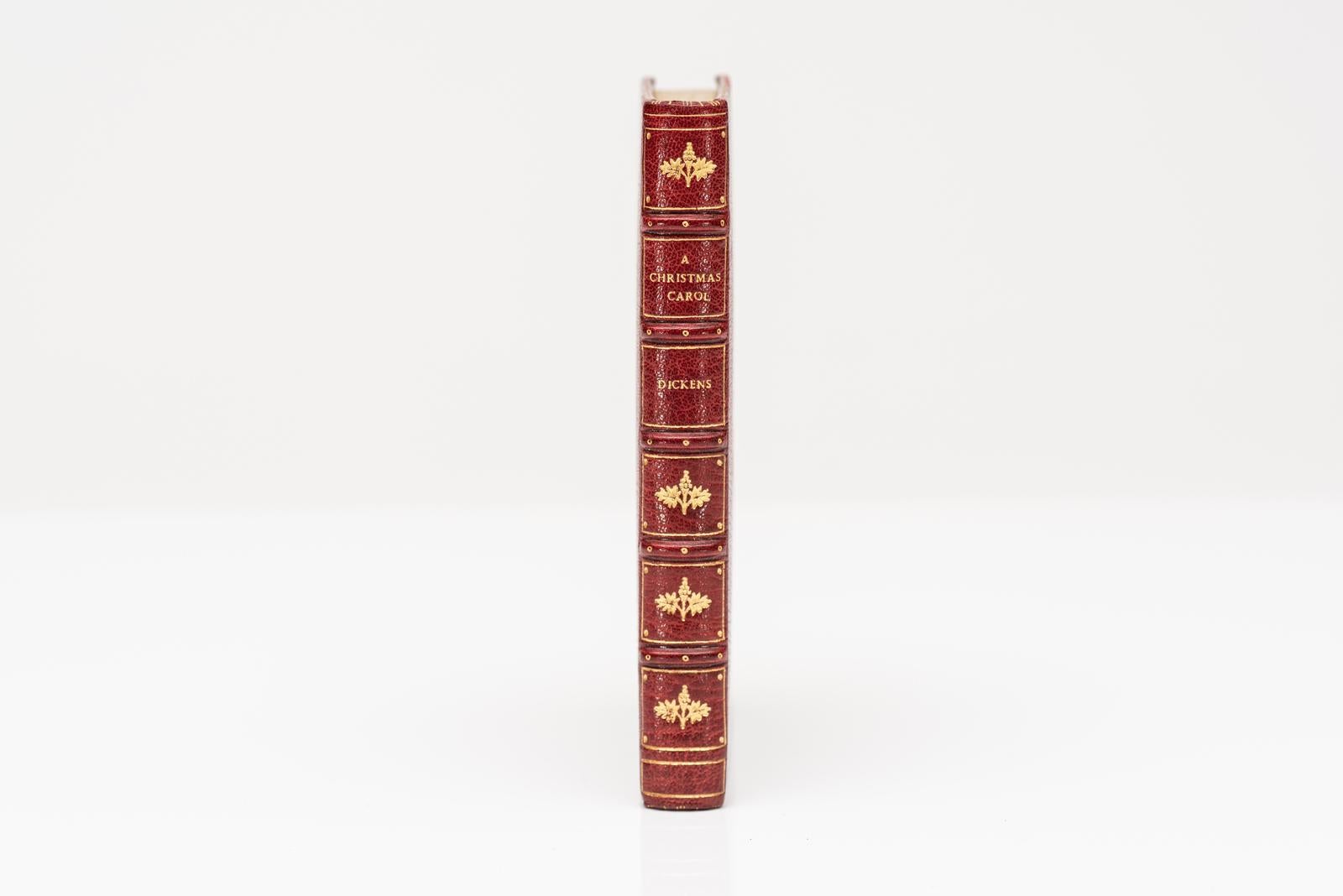 1 Volume. Charles Dickens. Un chant de Noël en prose, une histoire de fantômes de Noël. Édition en fac-similé. Reliure en plein maroquin rouge, bandes en relief, dorée sur les plats et le dos, le premier plat est orné d'une incrustation en maroquin