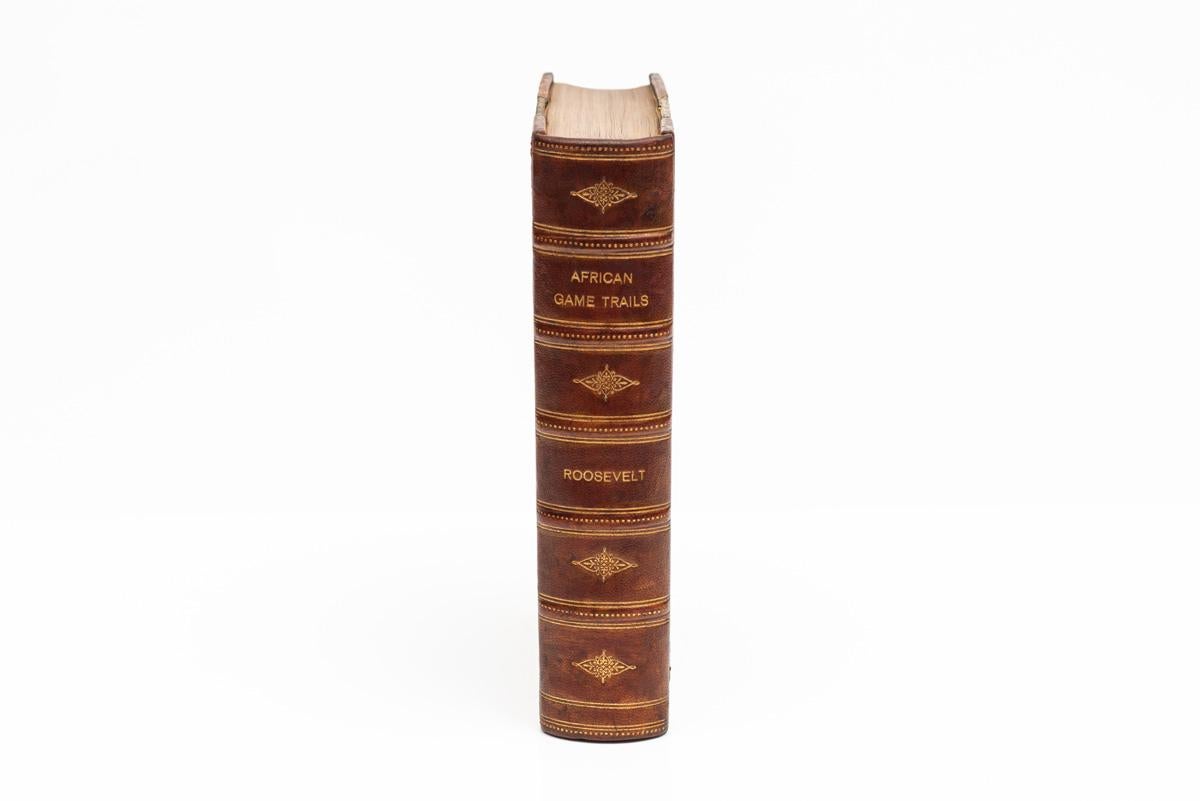 1 Volume. Theodore Roosevelt, Sentieri della selvaggina africana. Prima edizione. Rilegato in 3/4 di marocchino marrone con tavole marmorizzate e dorature sulle copertine e sul dorso a bande in rilievo. Carte da parati marmorizzate. Frontespizio