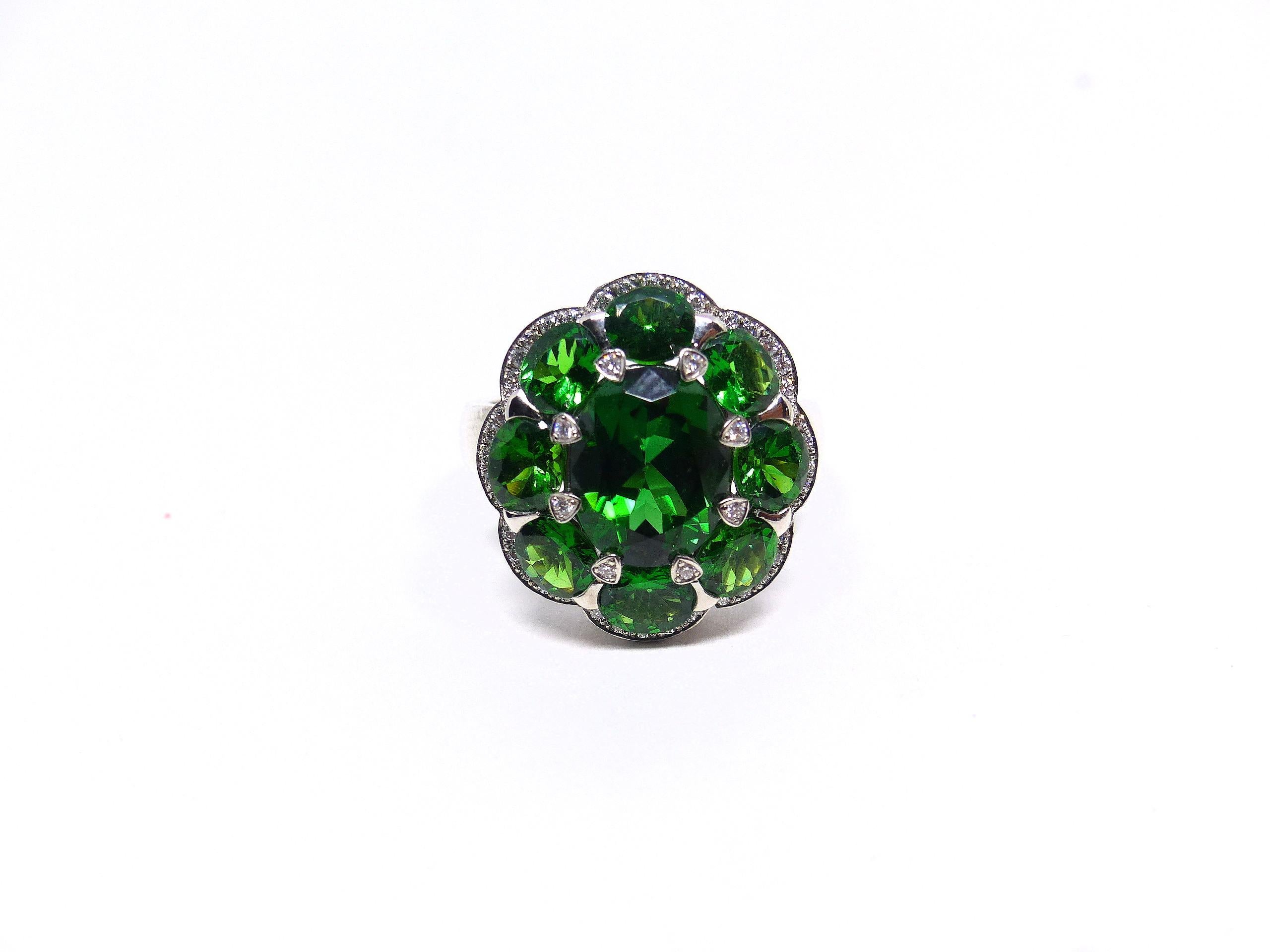 18k White Gold (8.25g) ring, set with: 

1x fine Chrome-Tourmaline in magnificient colour (oval, 10x8mm, 3.02ct) 

8x Tsavorites (oval, 5x4mm, 0.35ct) 

48x Diamonds (brilliant-cut, 1mm, 0.35ct)

Chrome Tourmalines are renowned for their hight light