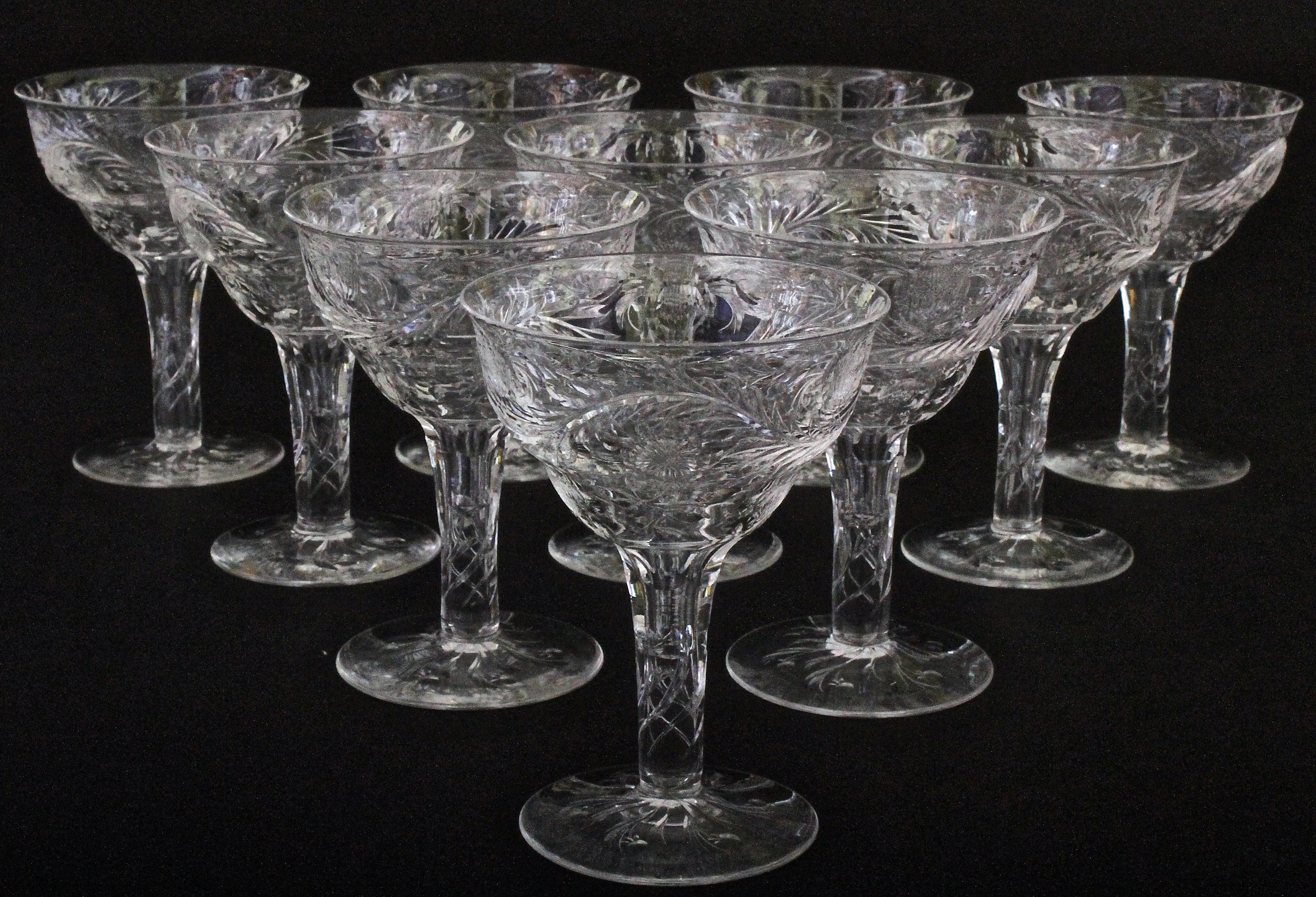 Here are 10 exceedingly rare hollow-stem rock crystal style champagne coupes by the distinguished English maker Thomas Webb. The coupes are hand-blow and wheel-cut in a lovely Art Nouveau flowing leaf and floral design. The hollow stem is an