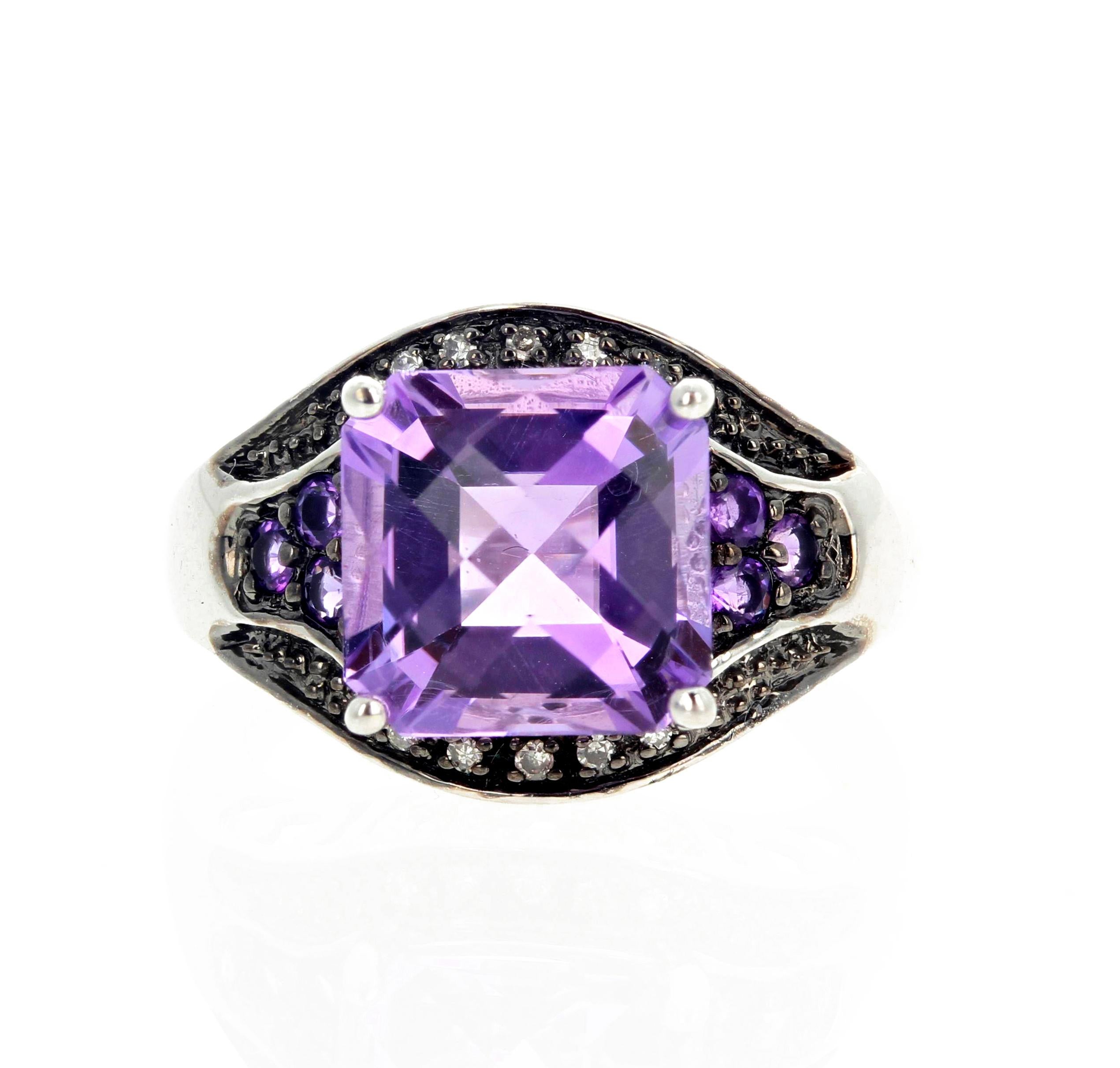 This brilliant checkerboard gem cut 10 carat Amethyst is enhanced with smaller Amethyst side stones and .05 carats of white sparkling Diamonds set in a rhodium plated Sterling Silver ring. .  The ring is a size 7 (sizable FOR FREE).  This is truly