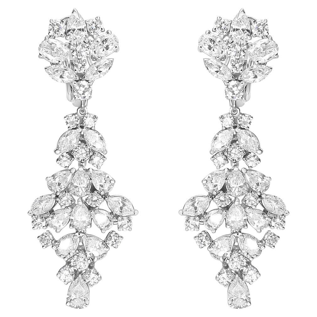 Exquisite white diamonds, these dazzling drop earrings for her feature marquise, oval, pear, and round shaped diamonds in a prong-setting and arranged in a cluster design. These geometric-inspired cluster earrings form a decadent display of