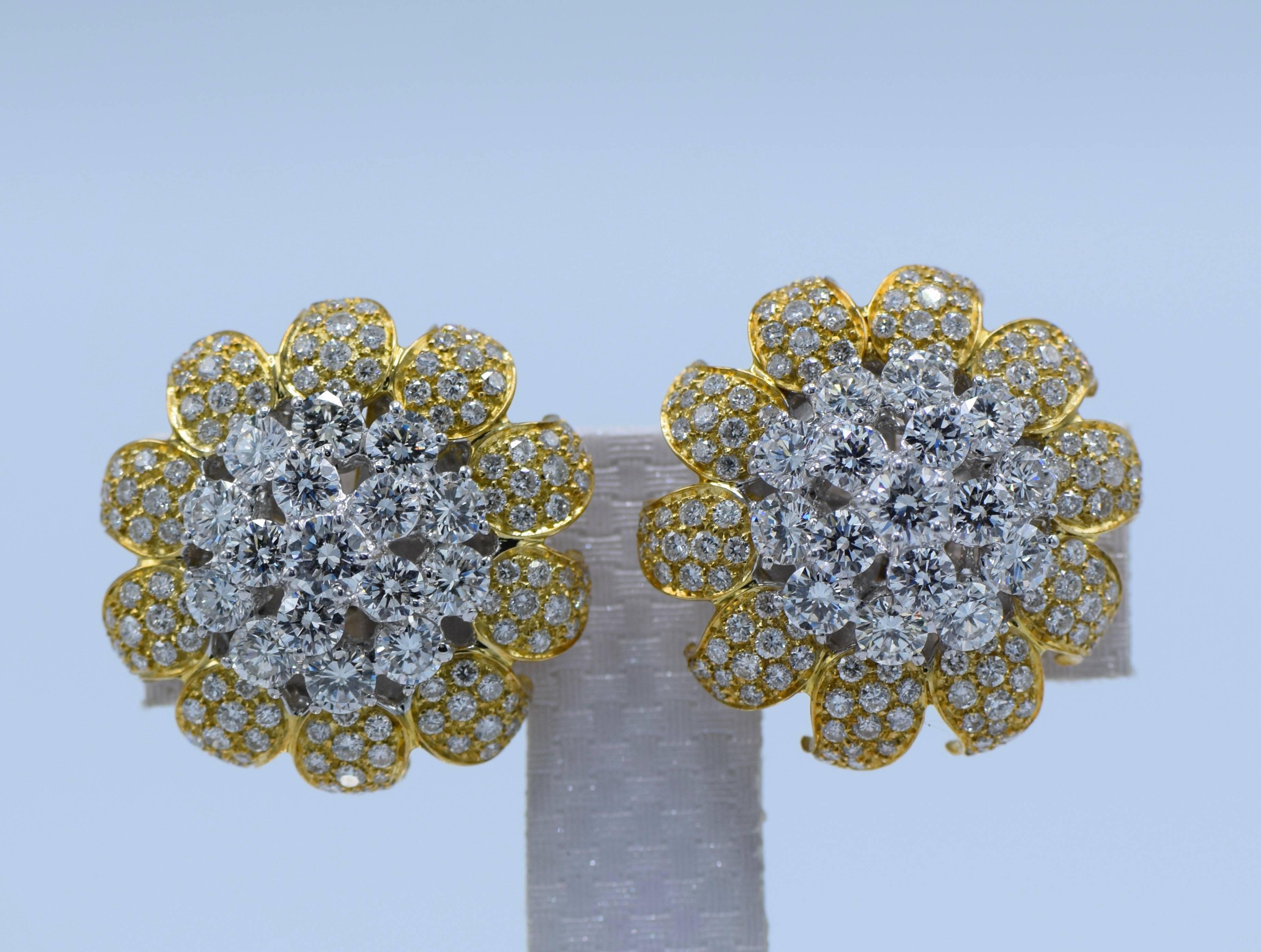 The large blossoming bomb flowerheads centred by tiered round diamond clusters surrounded by pav-set diamond petals, weighing approximately 10.00 carats, mounted in 18k white and yellow gold

Dimensions: 28 mm diameter 

Centre diamonds: 32 round