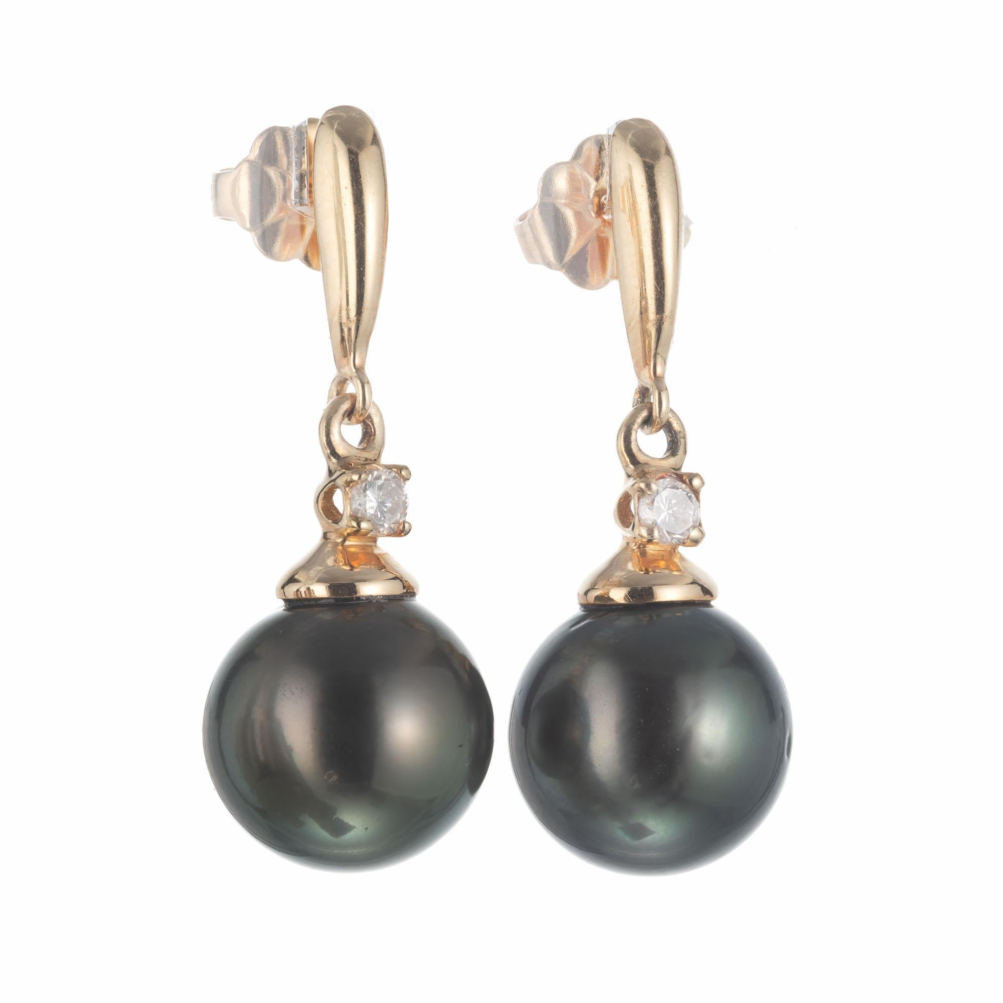 Natural color black 9.5mm cultured Japanese pearl dangle earrings with full cut accent diamonds in 14k yellow gold.

2 cultured black cultured 9.5mm pearls 
2 round brilliant cut diamonds, I-J SI2 approx. .10cts
14k yellow gold 
Stamped: 585
3.9