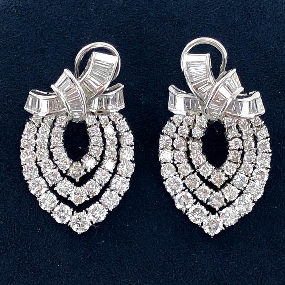 10-carats of brilliant white diamonds sparkle in these dangle earrings. The earrings are fashioned in 18 karat white gold, and are set with 122 baguette and round brilliant cut diamonds graded G-H color and VS clarity.  
They measure 1.0 x 1.5