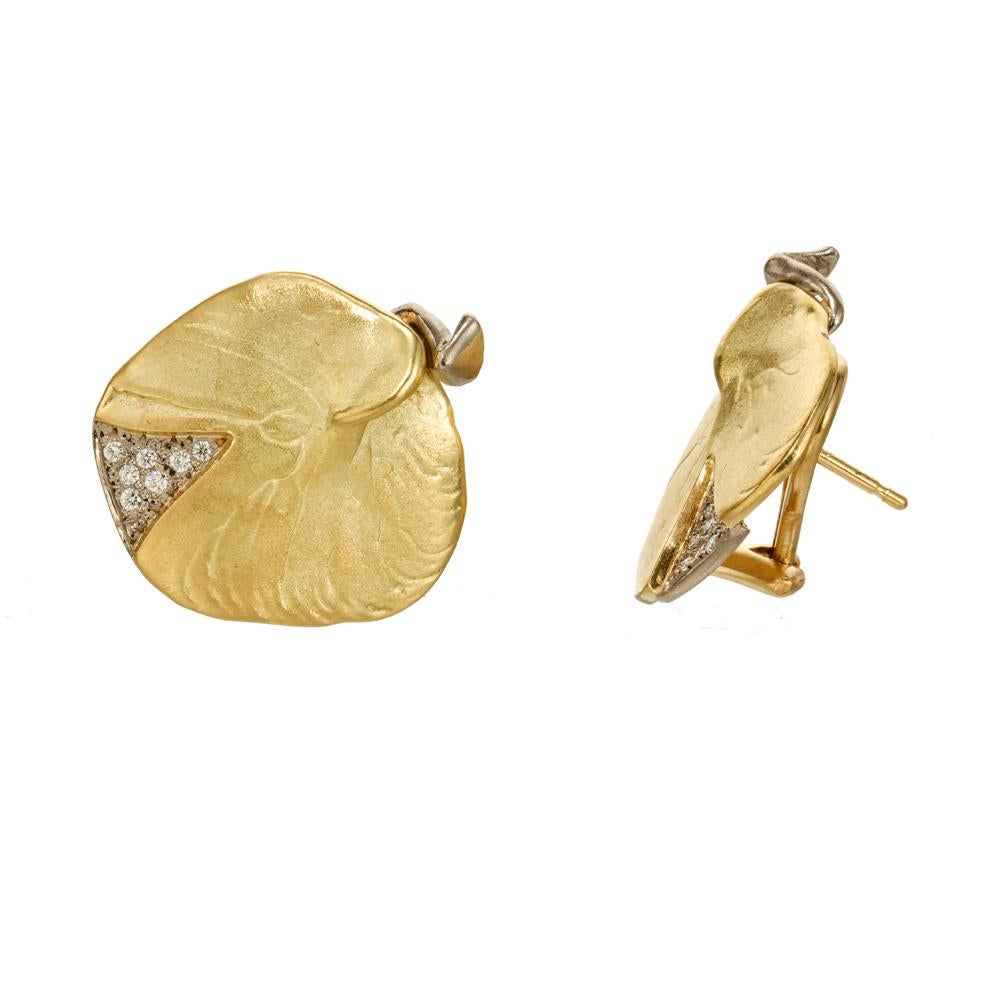 Artisan style diamond leaf design earrings.  Set with 14 round brilliant cut diamonds in 18k yellow and white gold clip post earrings. The hallmark on the back of the earrings is one one we do not recognize. A triangle within an upright triangle.