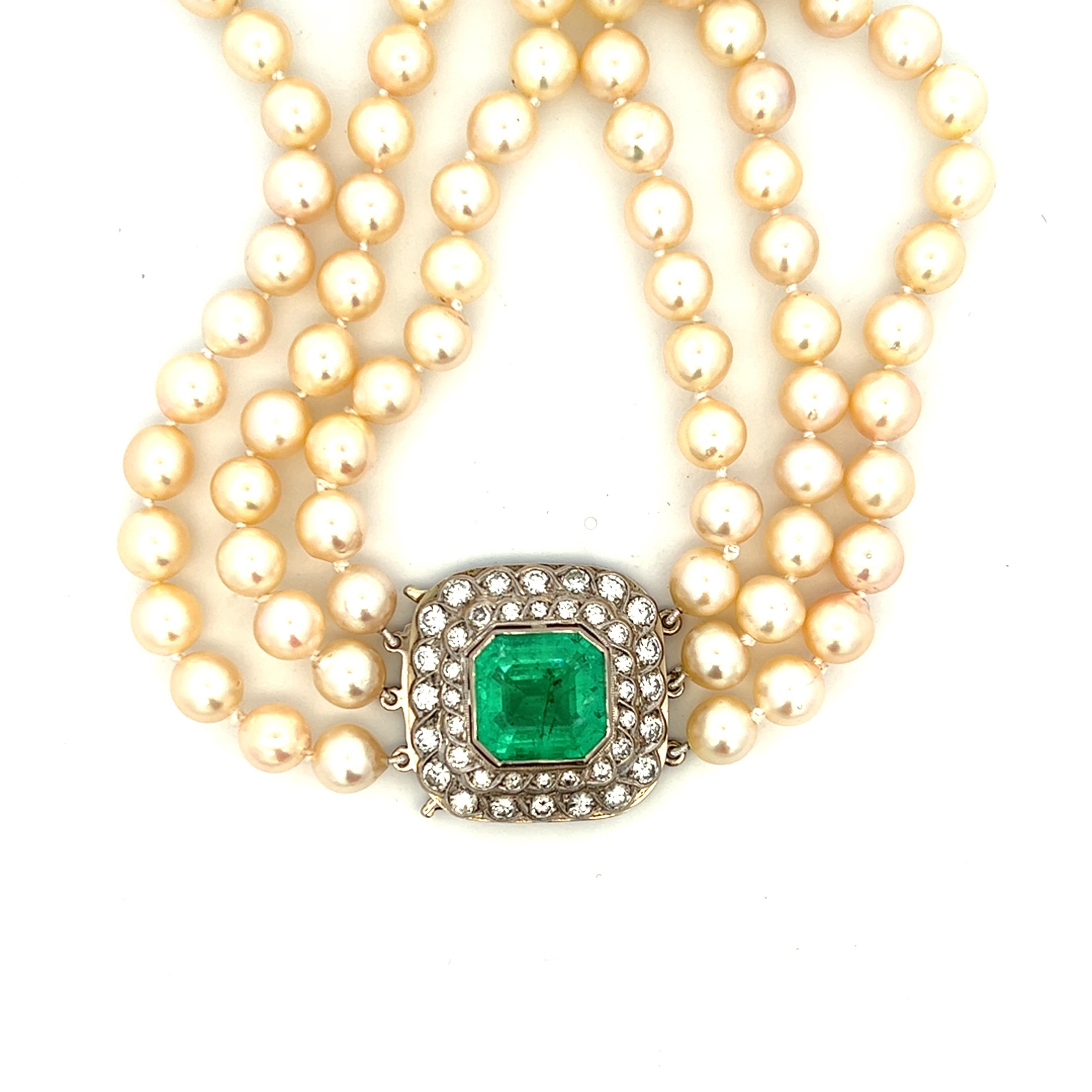 One 18 karat white gold triple strand freshwater pearl, emerald and diamond necklace, strung with seventy-eight (78) cream-colored freshwater pearls, measuring between 7.5-8mm. The necklace contains one 18 karat white gold square shaped pendant set