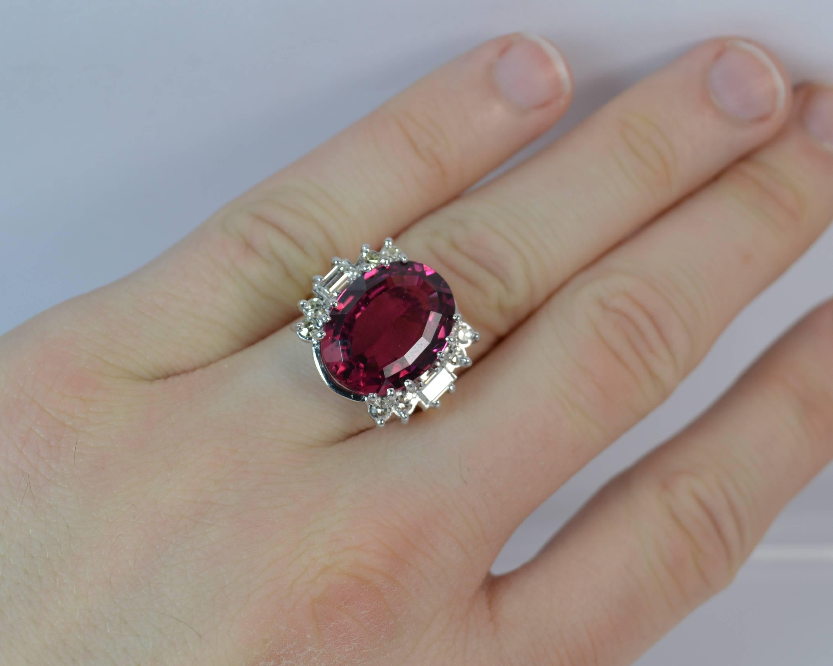 
A superb quality Pink Tourmaline and Diamond cluster ring.

Set with a large natural oval cut pink tourmaline to the centre in a twelve claw mount, 12.2mm x 16.2mm. Five natural diamonds to each side, a baguette cut and four round eight cuts to