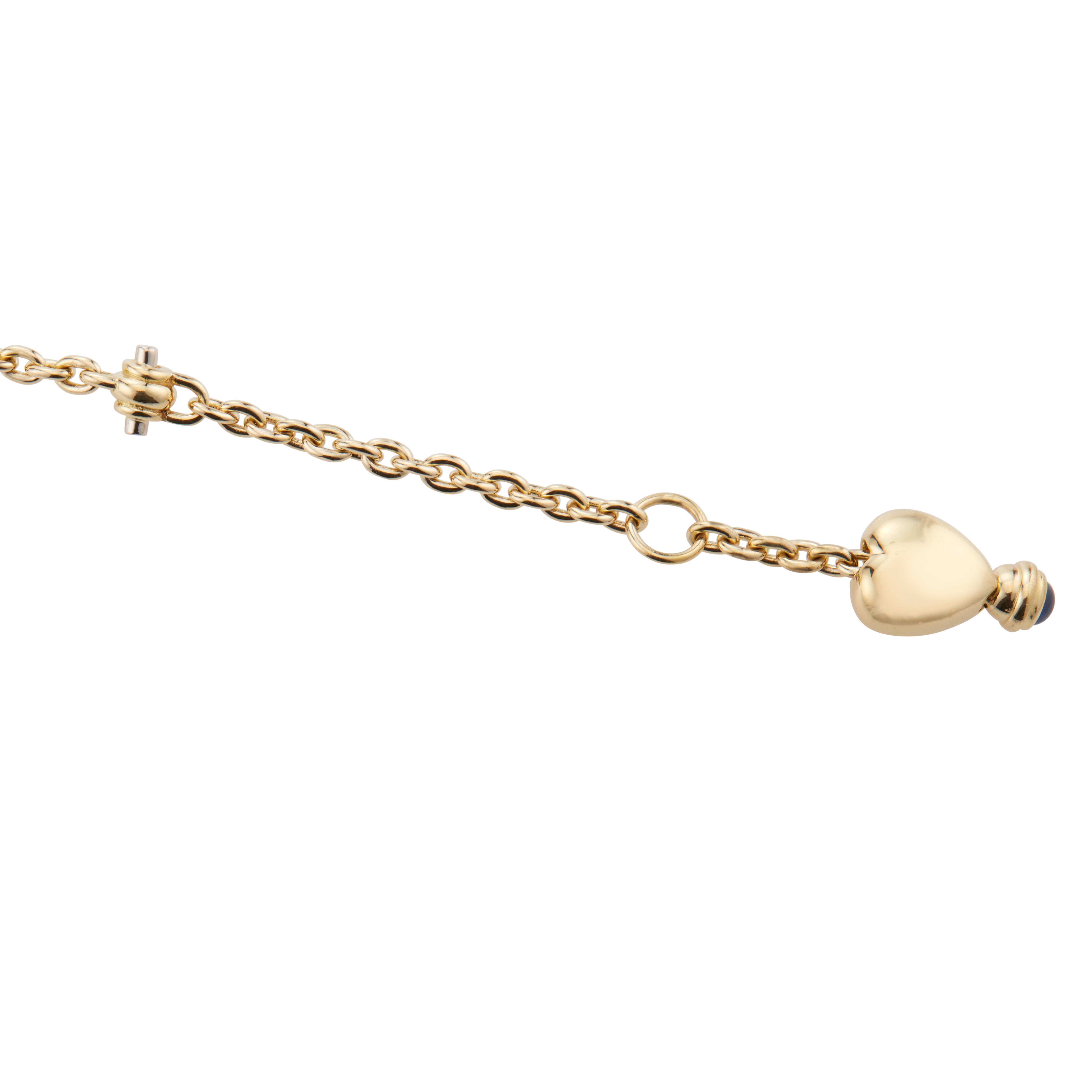 Sapphire heart link bracelet. 18k yellow gold link bracelet with a heart and cabochon drop dangle. 8.5 inches in length. 

1 blue cabochon sapphire, approx. .10cts
18k yellow gold
Stamped: 750
20.9 grams
Bracelet: 8 Inches
Total length: 8.5