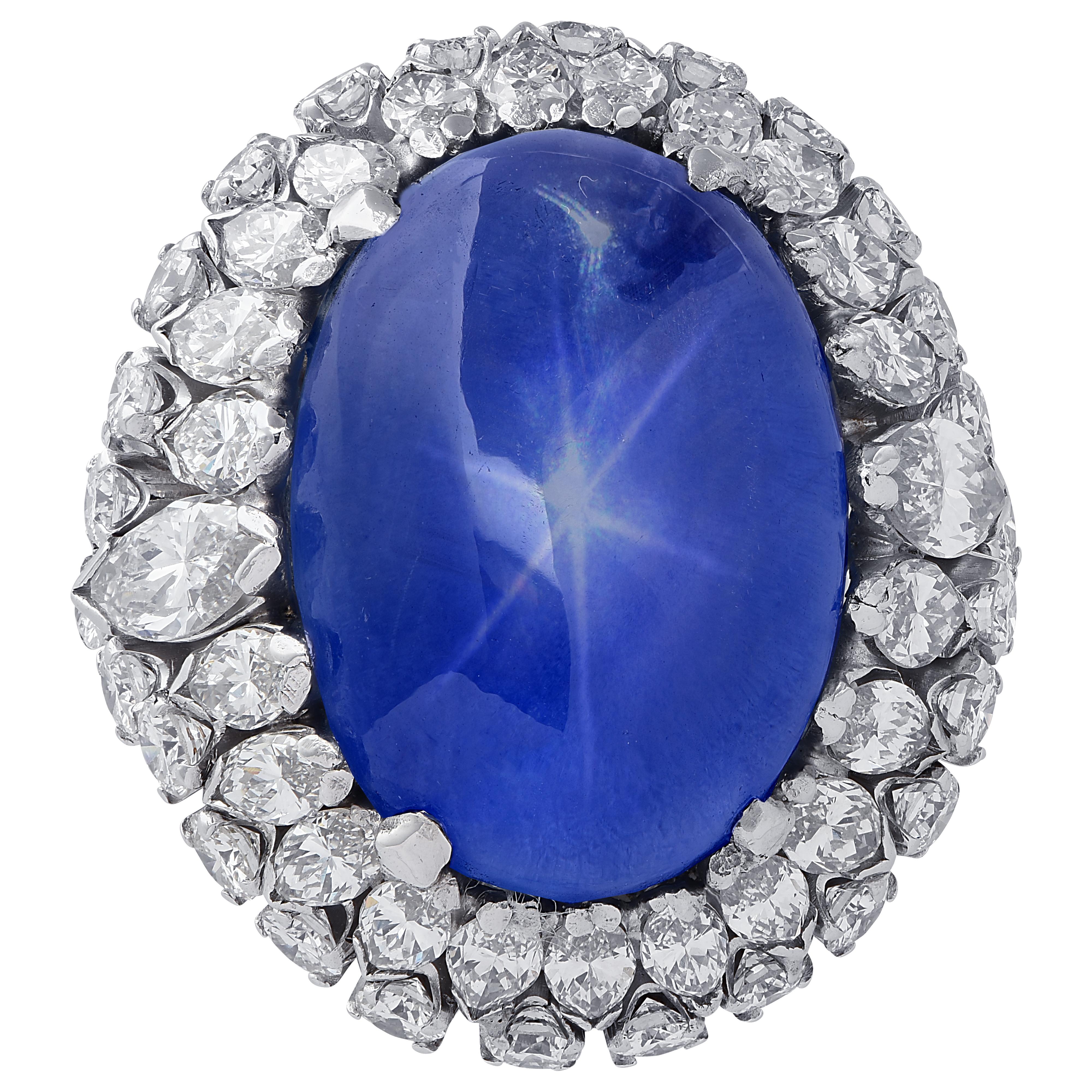 Spectacular ring crafted in platinum, showcasing a mesmerizing oval shape blue Star Sapphire cabochon weighing approximately 10 carats, resting on a bed of 51 marquise and round brilliant cut diamonds weighing approximately 2 carats total, G-I