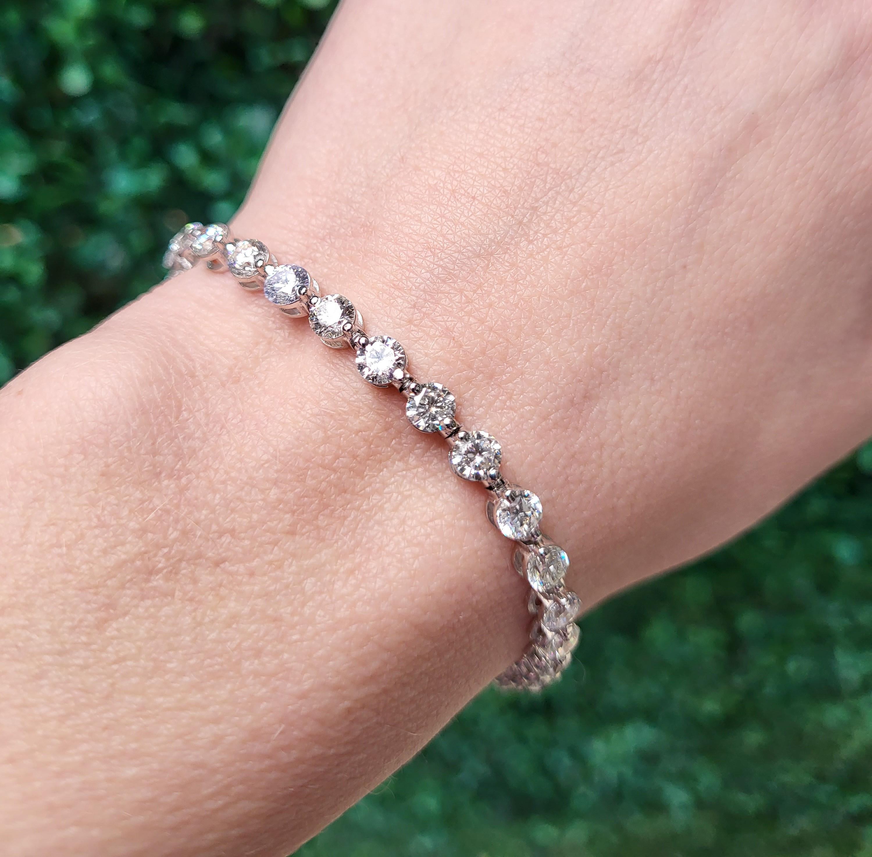 This diamond tennis bracelet features 10 carat total weight in single prong round brilliant cut diamonds set in 14 karat white gold. Box clasp with safety clasp. The length is 7