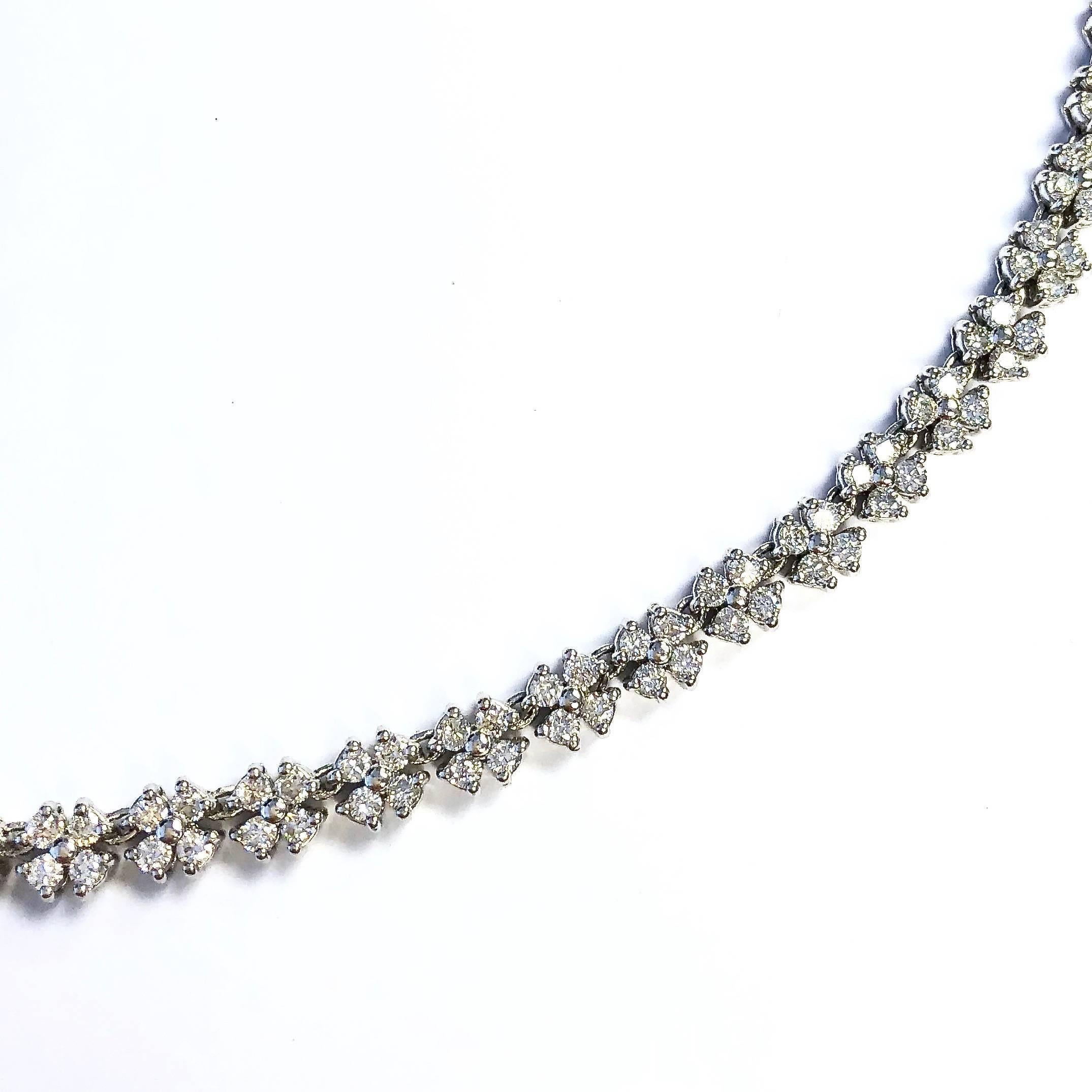 Elegant platinum necklace, composed of a series of four-diamond florets terminating in a hidden clasp with safety. 
272 round brilliant cut diamonds, total weight: 10ct (stamped on clasp). Color: G-H, Clarity: VS2-SI2
Length: 17 inches
Width: 6