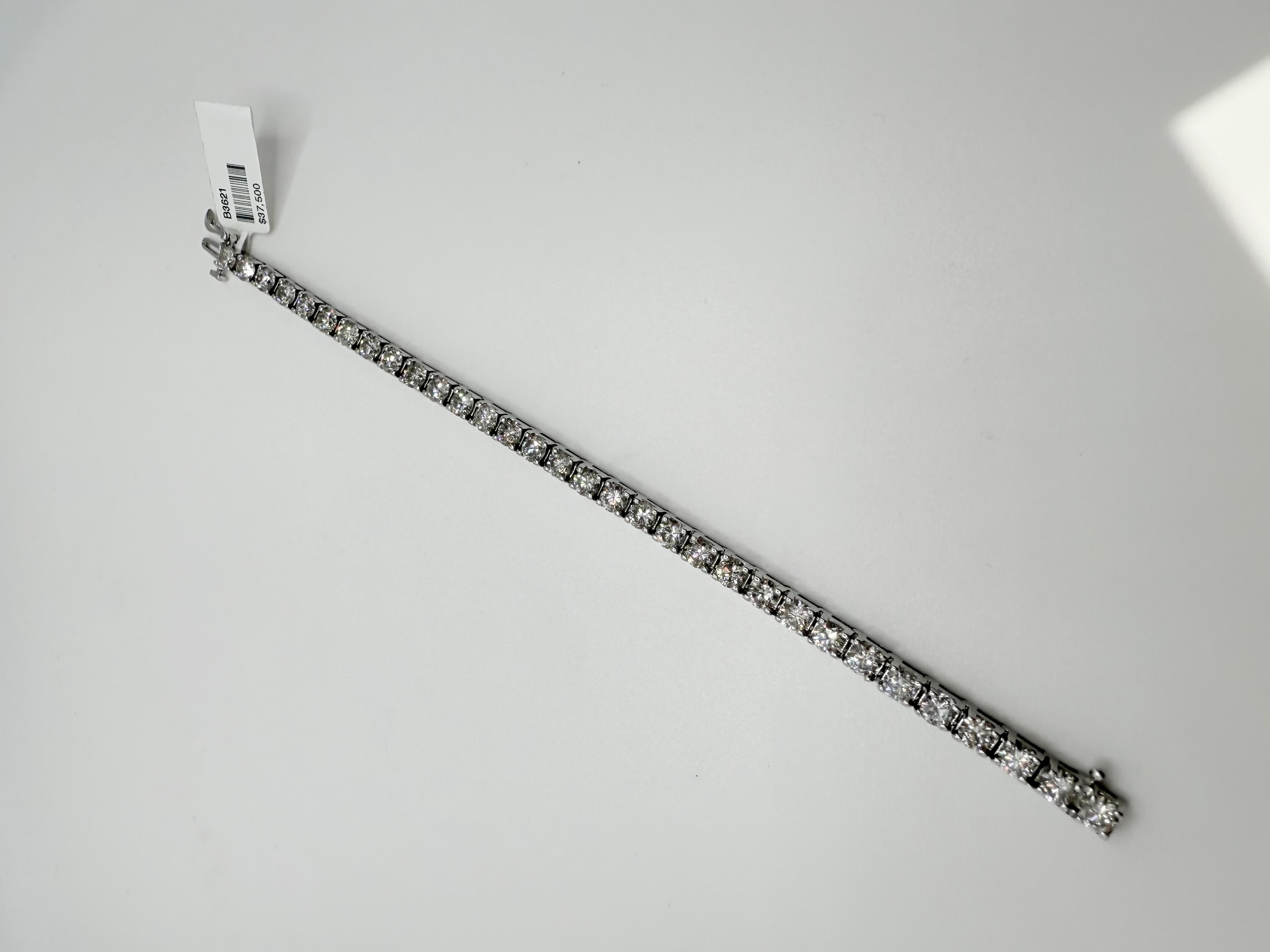 Este brazalete de tenis de diamantes es un ejemplo sorprendente de diseño atemporal y lujo perdurable. Elaborado por expertos en oro blanco de 14 quilates, presenta una línea continua de diamantes redondos talla brillante que suman un impresionante