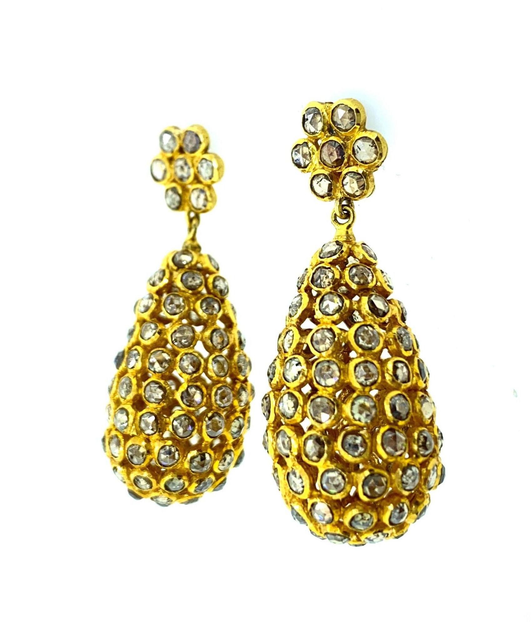 10 ct Diamond Earring in 18K Yellow Gold. The earring has been hand made in India and diamonds are all bezel set. The top stud of the earring has been finely crafted as a flower with diamonds and the bottom is a tear drop shaped all around diamonds.