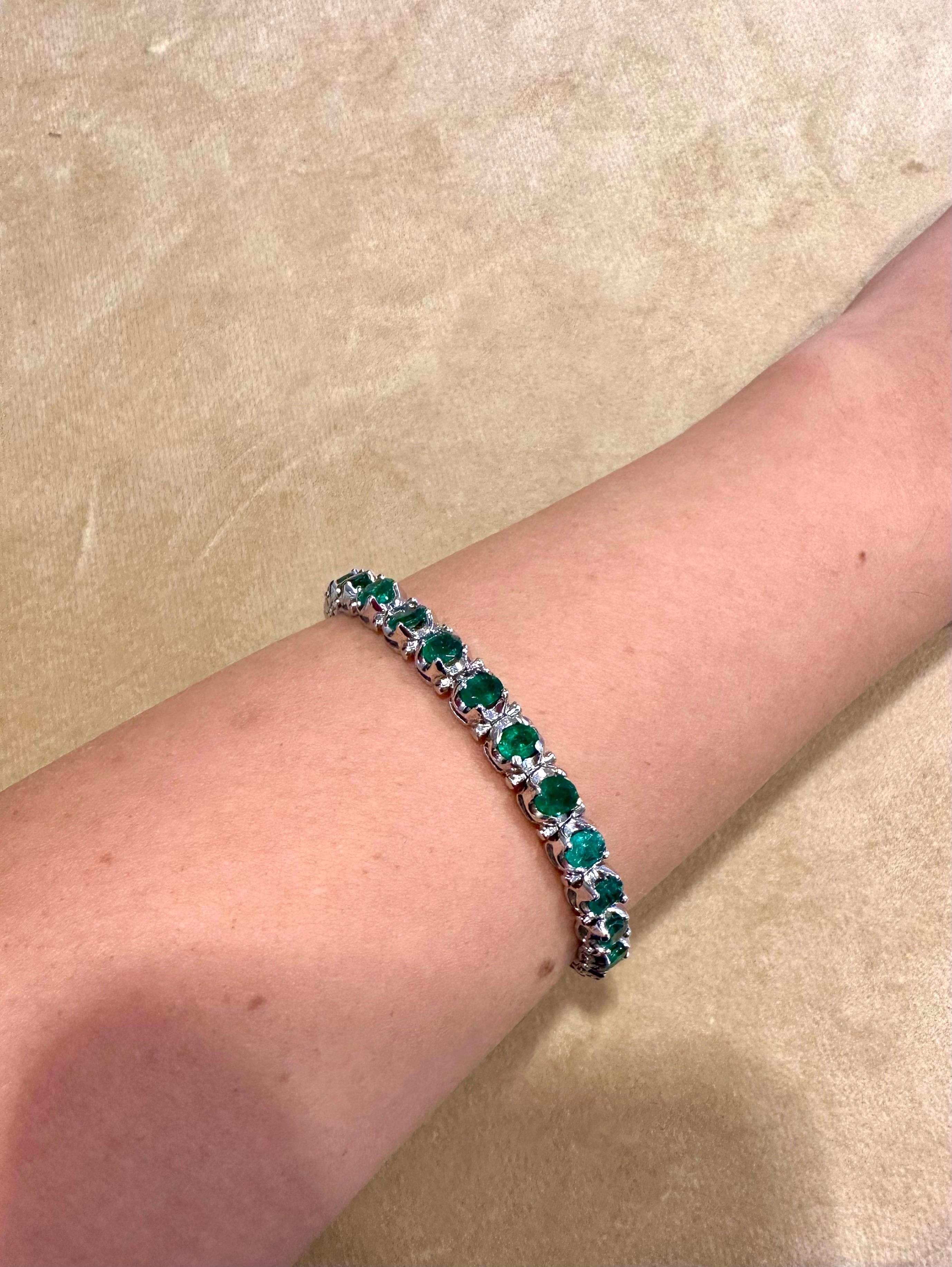 Introducing the exquisite Approximately 10 Ct Natural Oval Brazilian Emerald Tennis Bracelet in Platinum, measuring 7.5 inches in length. This stunning bracelet showcases 28 oval emeralds with a total approximate weight of 10 carats, creating a