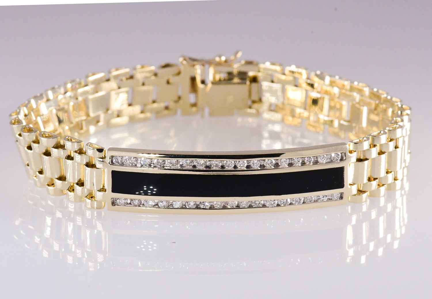 Large elegant diamond and onyx 14 karat yellow gold bracelet measuring 8.25 inches long. The center inlay onyx is flanked by two rows of round brilliant cut diamonds totaling 1.0 carat. The quality is SI2-I2; I-L  The weight of the bracelet is 35.6