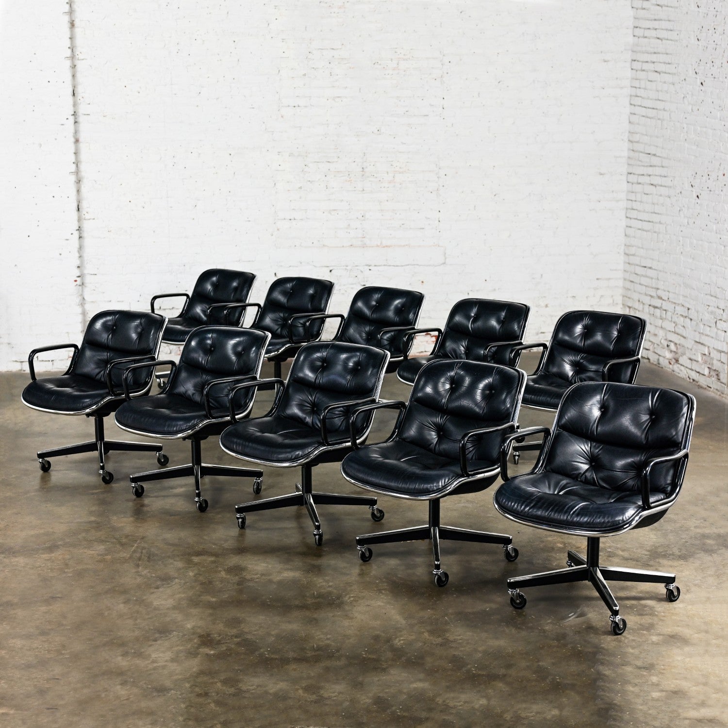 Incredible MCM (Mid-Century Modern) to Modern Executive armchairs by Charles Pollock for Knoll set of 10. Each chair is comprised of a black leather seat and back with button detail, aluminum band, chrome shaft, black plastic arms, and a 4-prong
