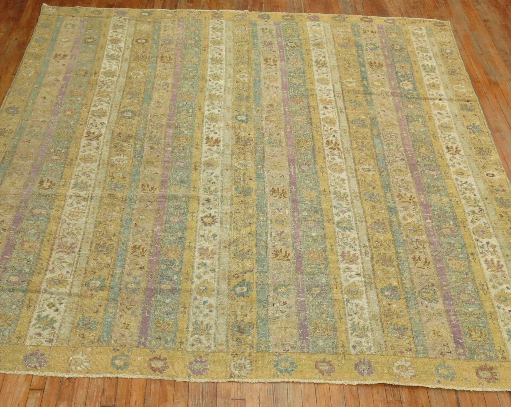 A square size early 20th century Turkish Ghiordes rug having an all-over pattern of narrow vertical floral meander stripes in khaki, lavender, sand, mint, and brown accents within a narrow sandy motif border. Size is original. The ghiordes village