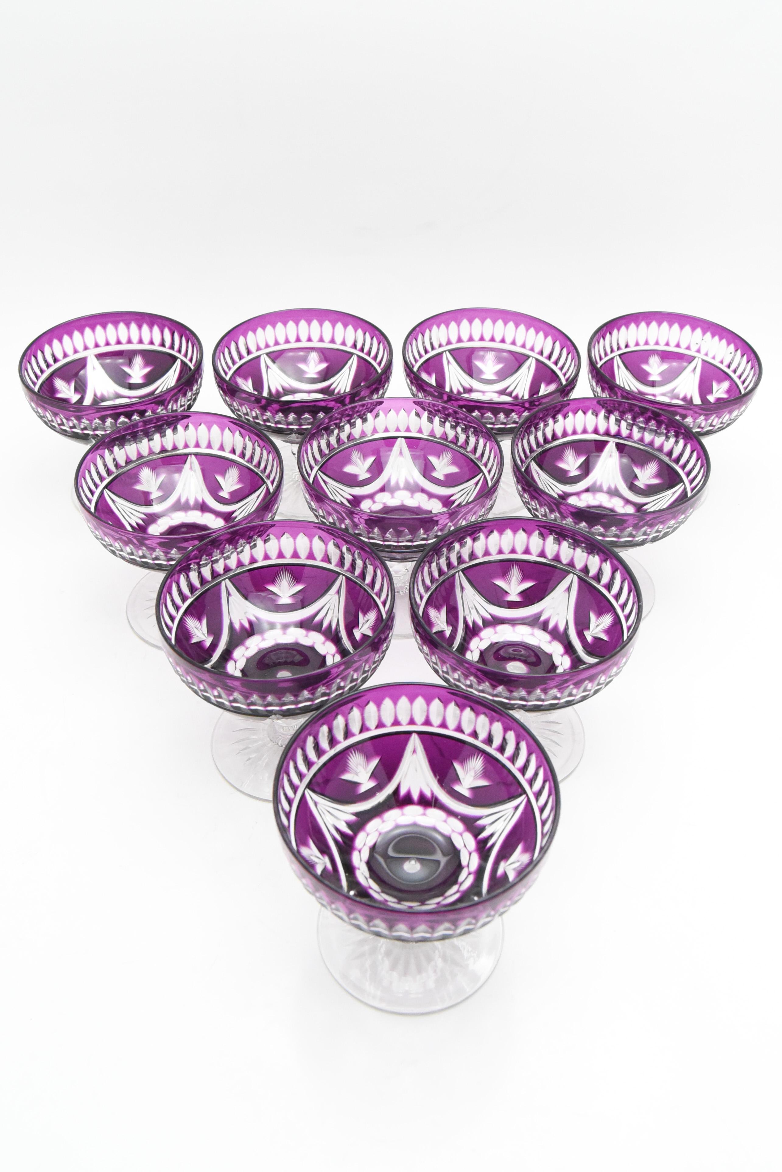The vibrant and rich amethyst overlay makes quite a statement on this rare set of 10 Baccarat champagne coupes. The pattern evokes both an Art Deco aesthetic and Arts and Crafts as well; clean geometric lines and rich, deep purple! Raise a glass and