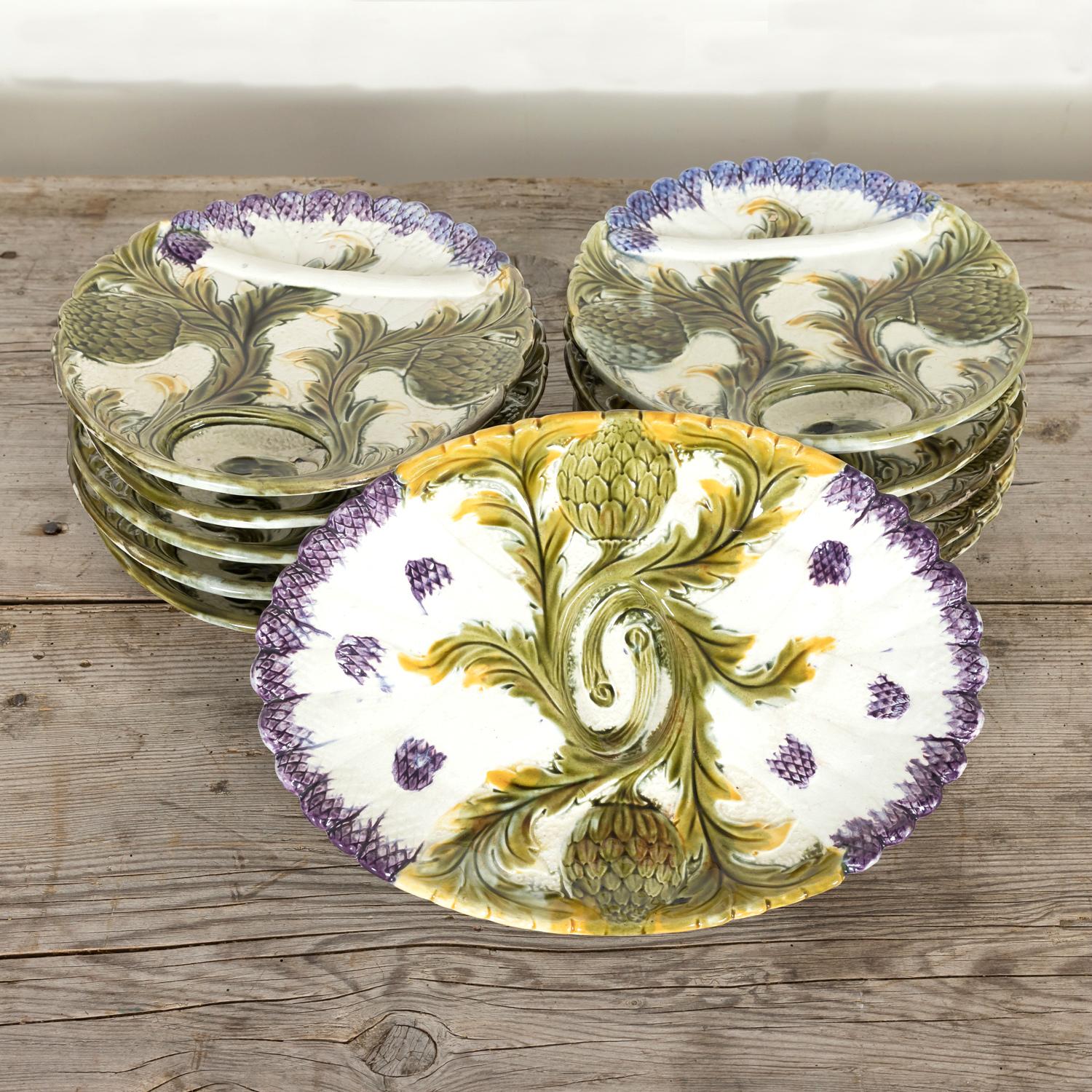 A rare and exceptional 19th century set of 10 majolica glazed French faïence barbotine artichoke and asparagus plates complete with oval shaped master server or platter by Orchies, circa 1880s. In the Art Nouveau style, this individually molded,