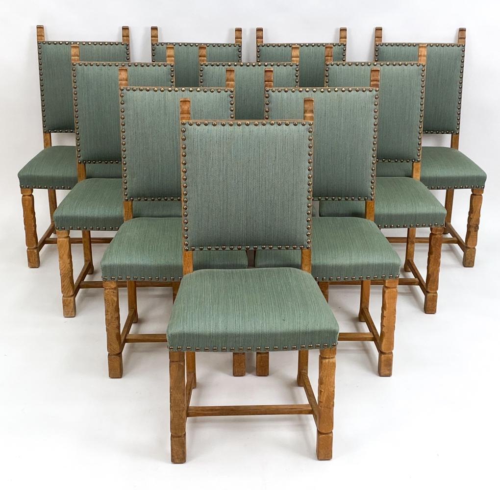 A set of six Danish midcentury dining side chairs by designer Henning Kjaernulf, well-renowned for his iconic farmhouse-inspired carved oak furniture designs, c. 1960s. These charming Provincial chairs feature low sculpted backs, an upholstered