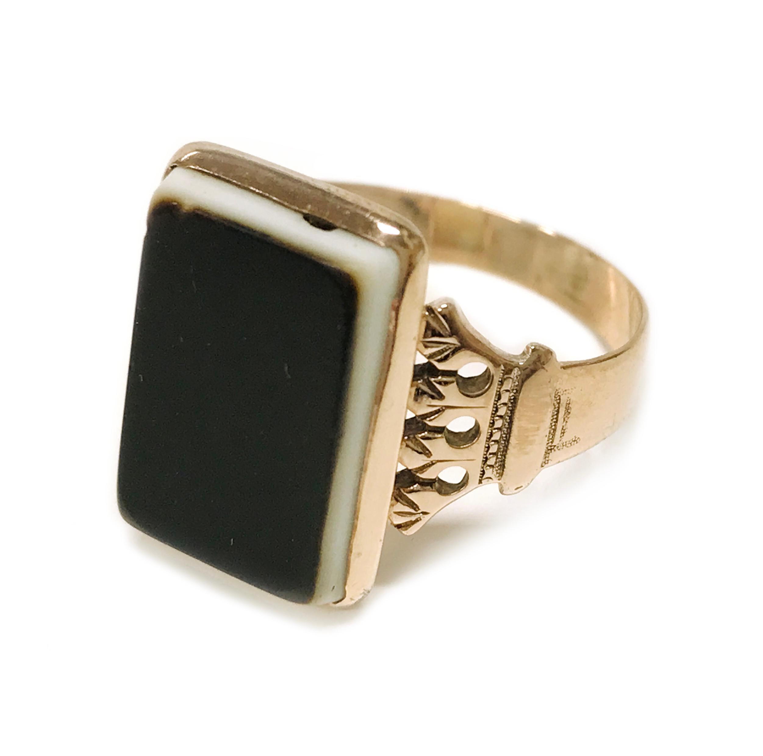 Anello in sardonica Art Deco a 10 carati, anni '40 circa. La pietra rettangolare misura 15 mm x 10 mm. Il cinturino presenta un motivo Art Deco con dettagli in graniglia. La parte superiore della pietra presenta usura e graffi. La misura dell'anello
