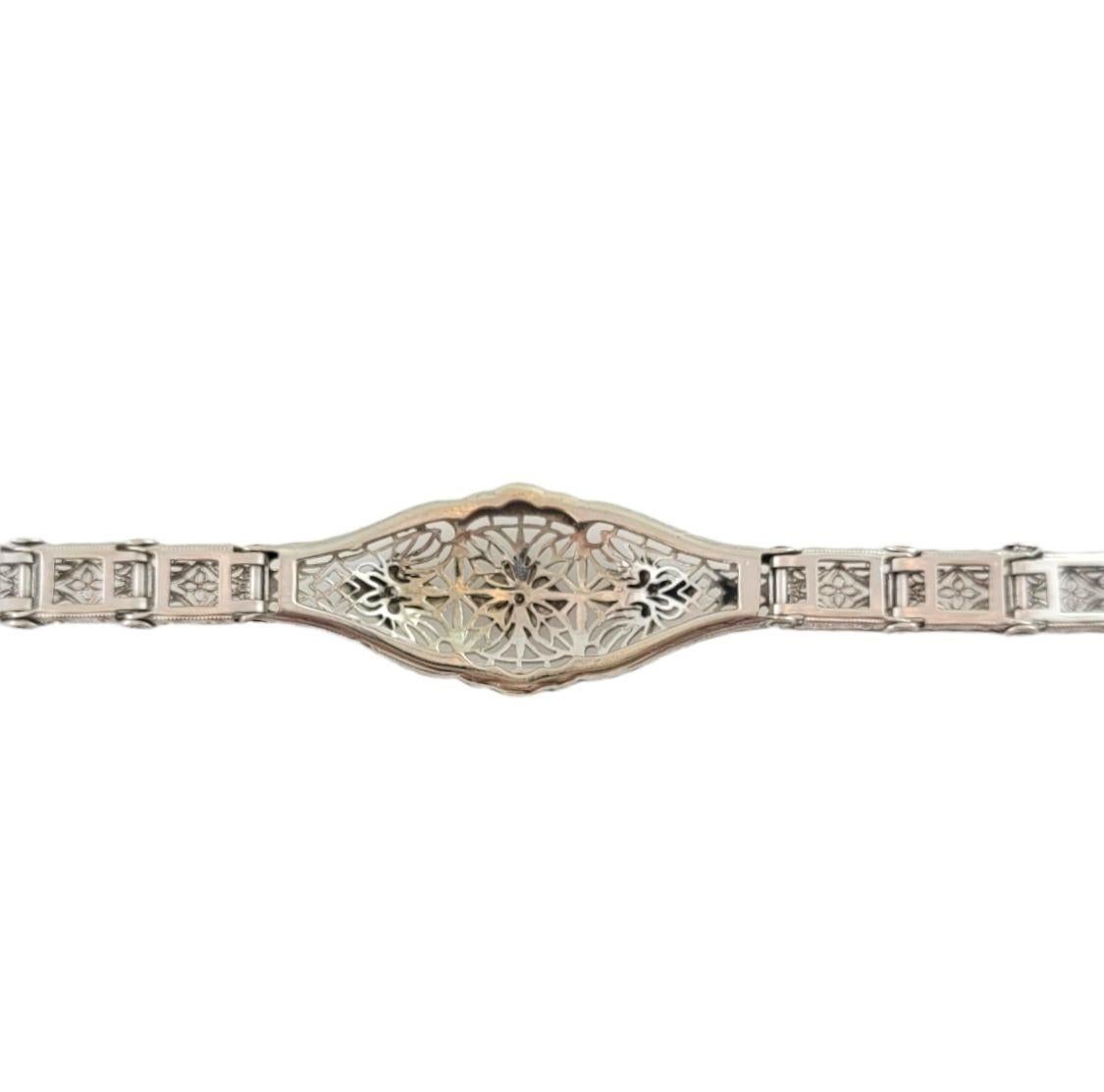 This elegant bracelet features two round single cut diamonds set in beautifully detailed 10K white gold filigree. Width: 10 mm.

Approximate total diamond weight: .04 ct.

Diamond color: I

Diamond clarity: I1

Ring Size:  6.5 inches

Weight:  7.3