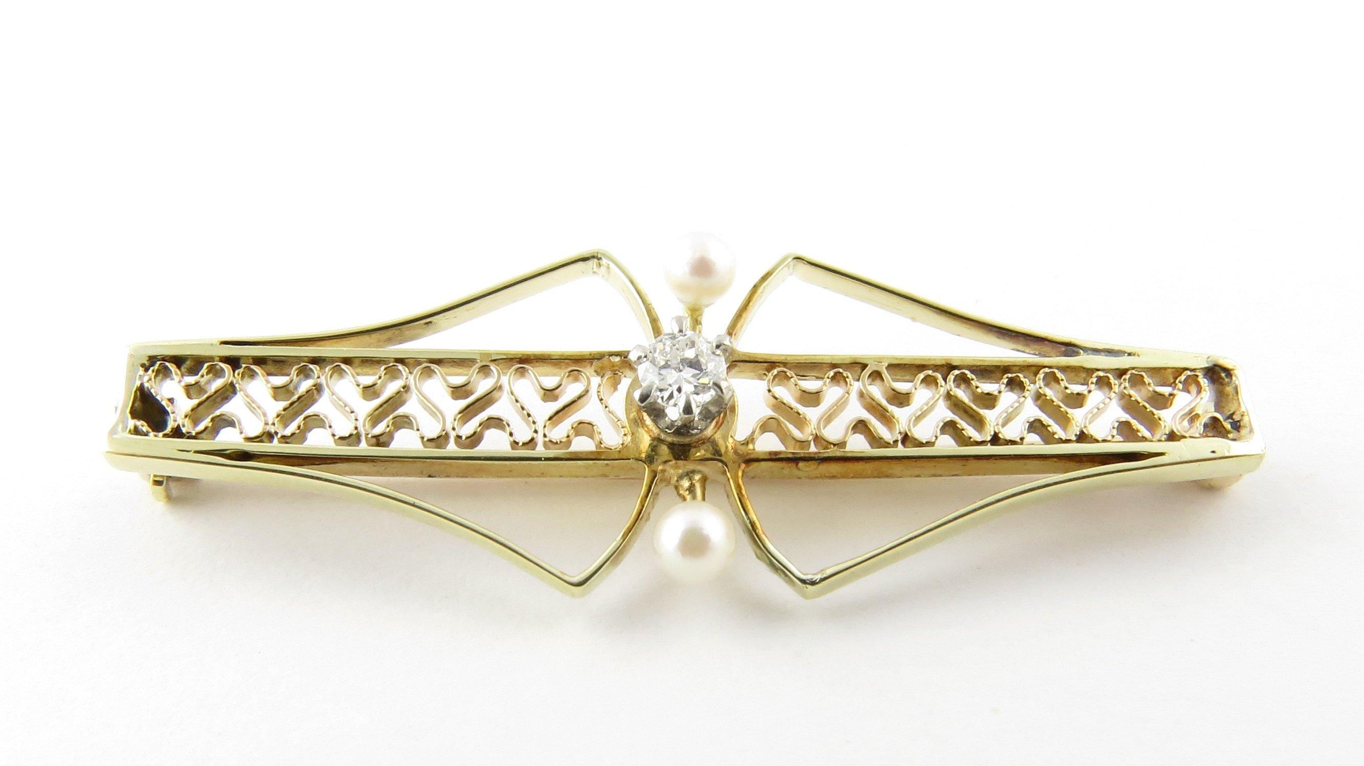 Vintage 10 Karat Yellow Gold and Pearl Brooch/Pendant- 
This elegant pin features one round brilliant cut diamond and two white seed pearls set in lovely gold filigree. 
Diamond is approx. .07 cts and of I1 clarity, H color
Size: 39 mm x 13 mm