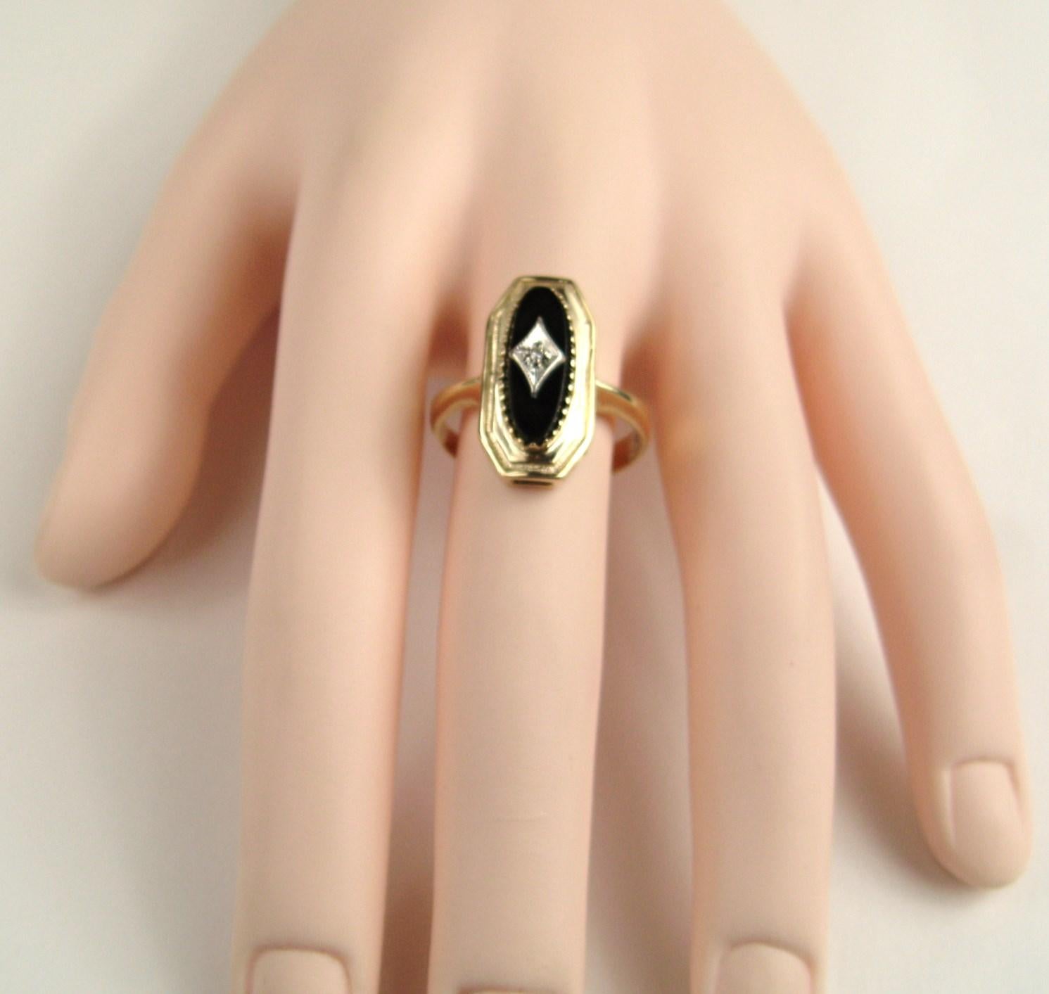 Cette magnifique bague contient un onyx noir ovale central qui contient une plaque en or blanc en forme de diamant qui contient un diamant taille ancienne mine. L'anneau est un 10.5 et peut être dimensionné par nous ou votre bijoutier. N'oubliez pas