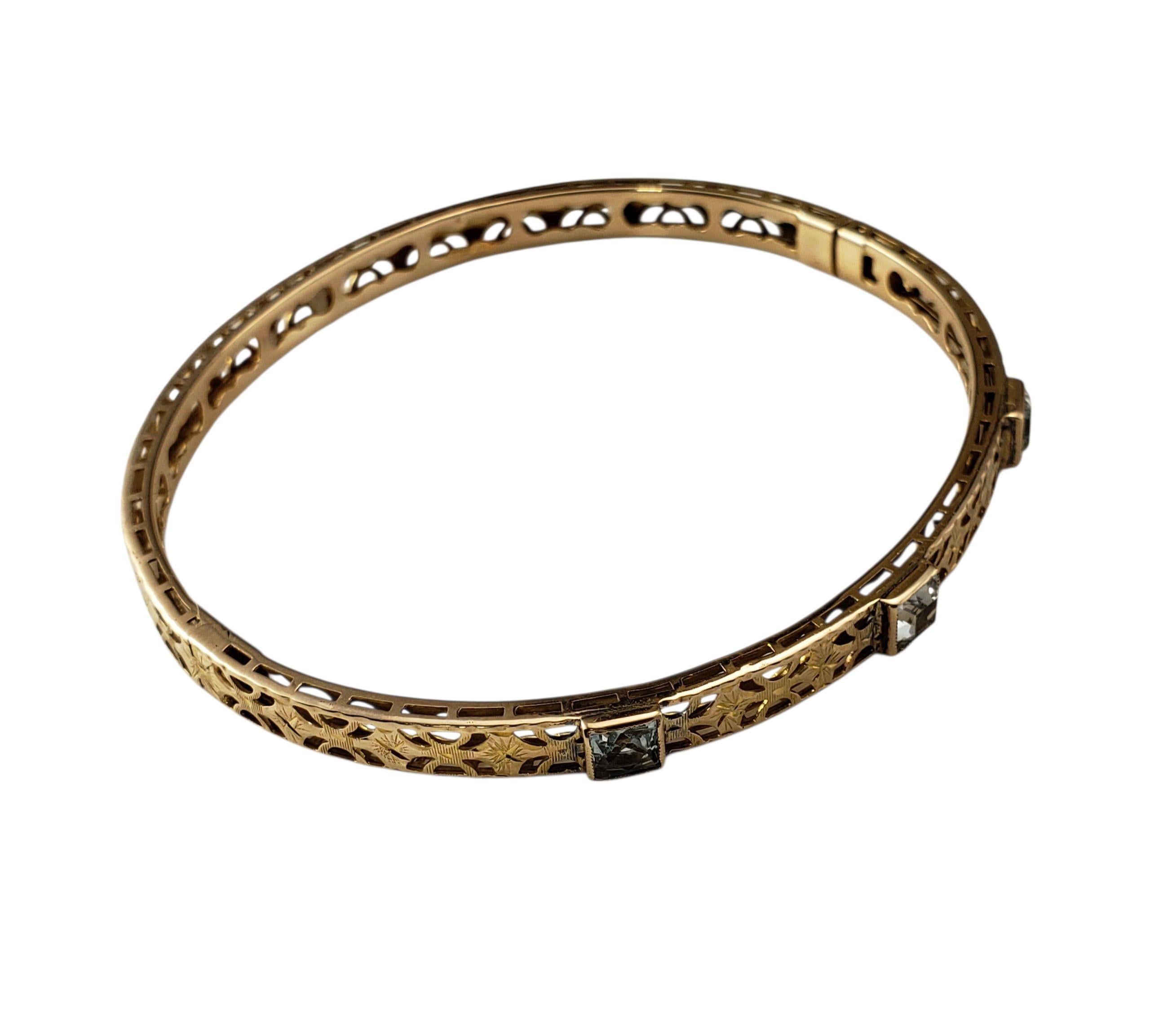 Bracciale in oro giallo 10 carati con filigrana e pietre preziose blu.

Questo grazioso braccialetto bangle in oro giallo 10K presenta dettagli in filigrana e cinque pietre quadrate azzurre incastonate che aggiungono un tocco di colore e un
