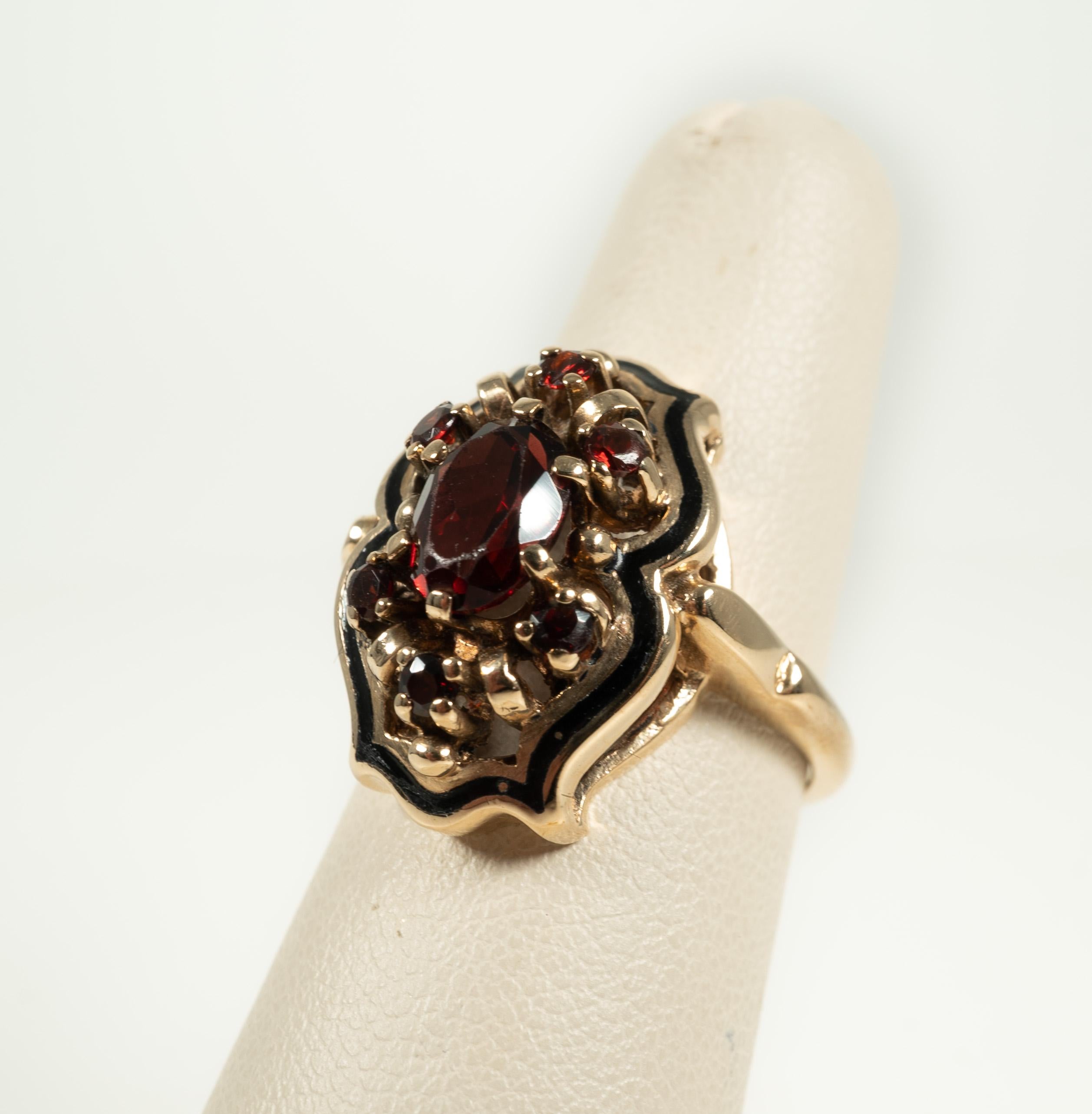 Such a beauty from an earlier time!  The lovely garnet is accented by black enamel. Size 6 3/4.