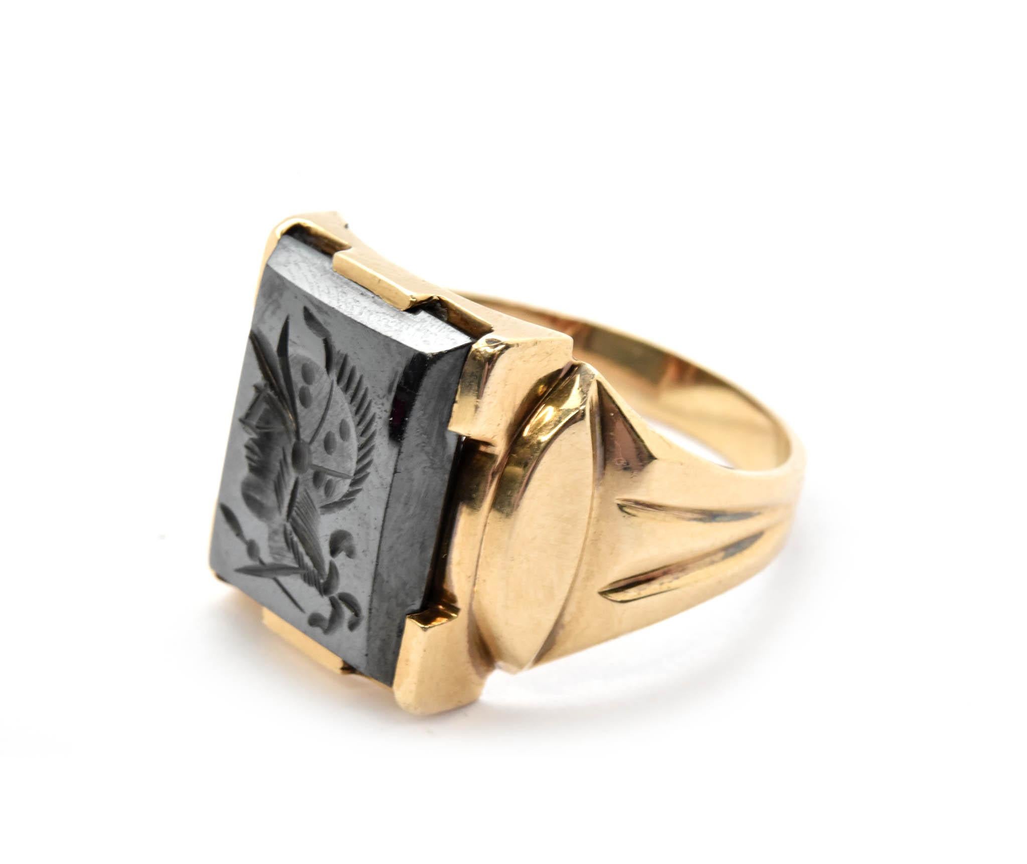 This is a 10k yellow gold gents ring set with a majestic hematite intaglio of a Roman warrior on the top of the ring. The hematite measures 16x12mm. The setting is decorated with grooves on the shoulder of the band. The current size of this ring is