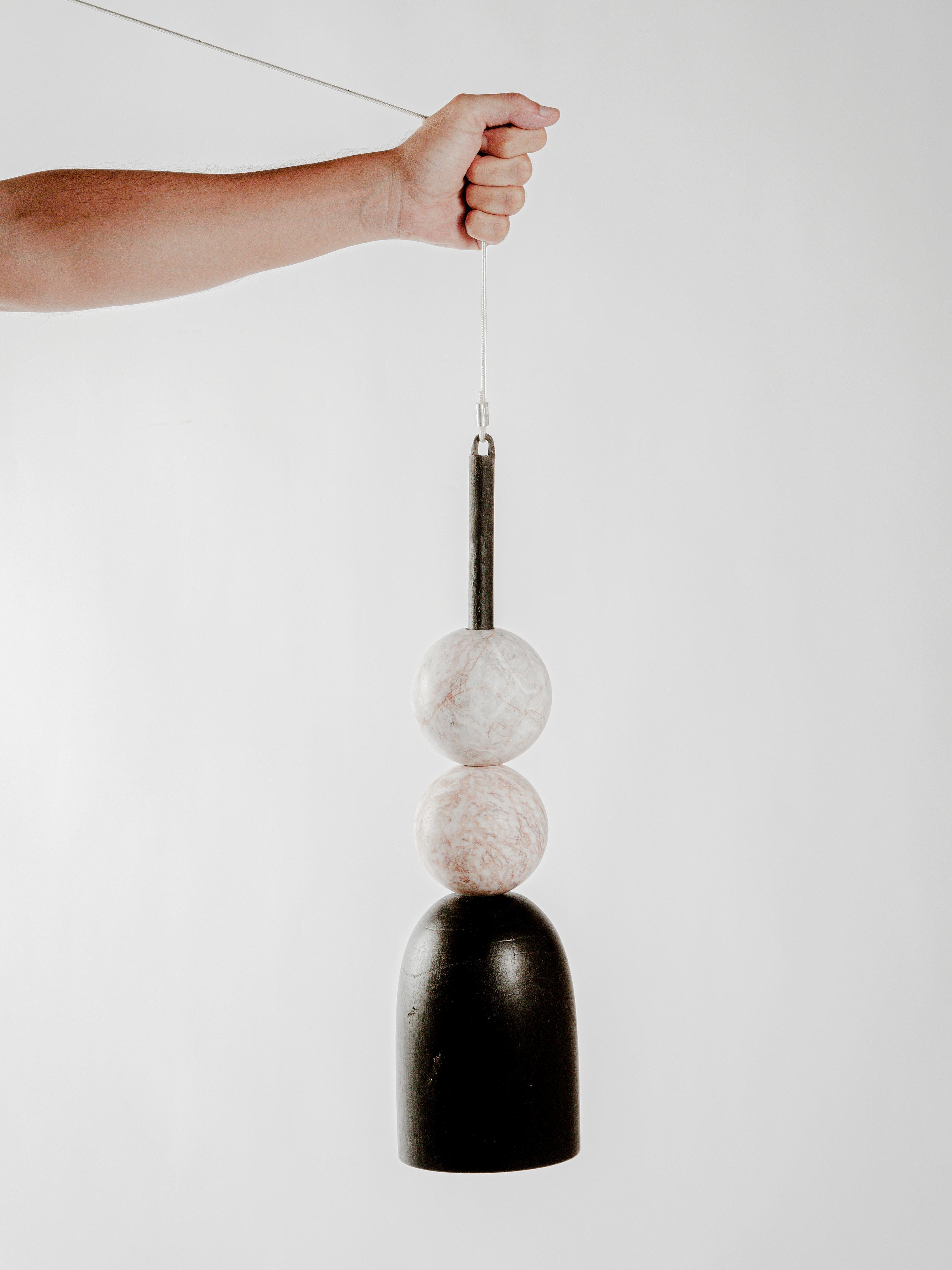 10 Lamp by Daniel Orozco
Dimensions: D 13 x H 40 cm.
Materials: Wood, Marble

Black wood -based pendant lamp and 2 pink marble balls. Handmade by Mexican artisans.

All our lamps can be wired according to each country. If sold to the USA it will be