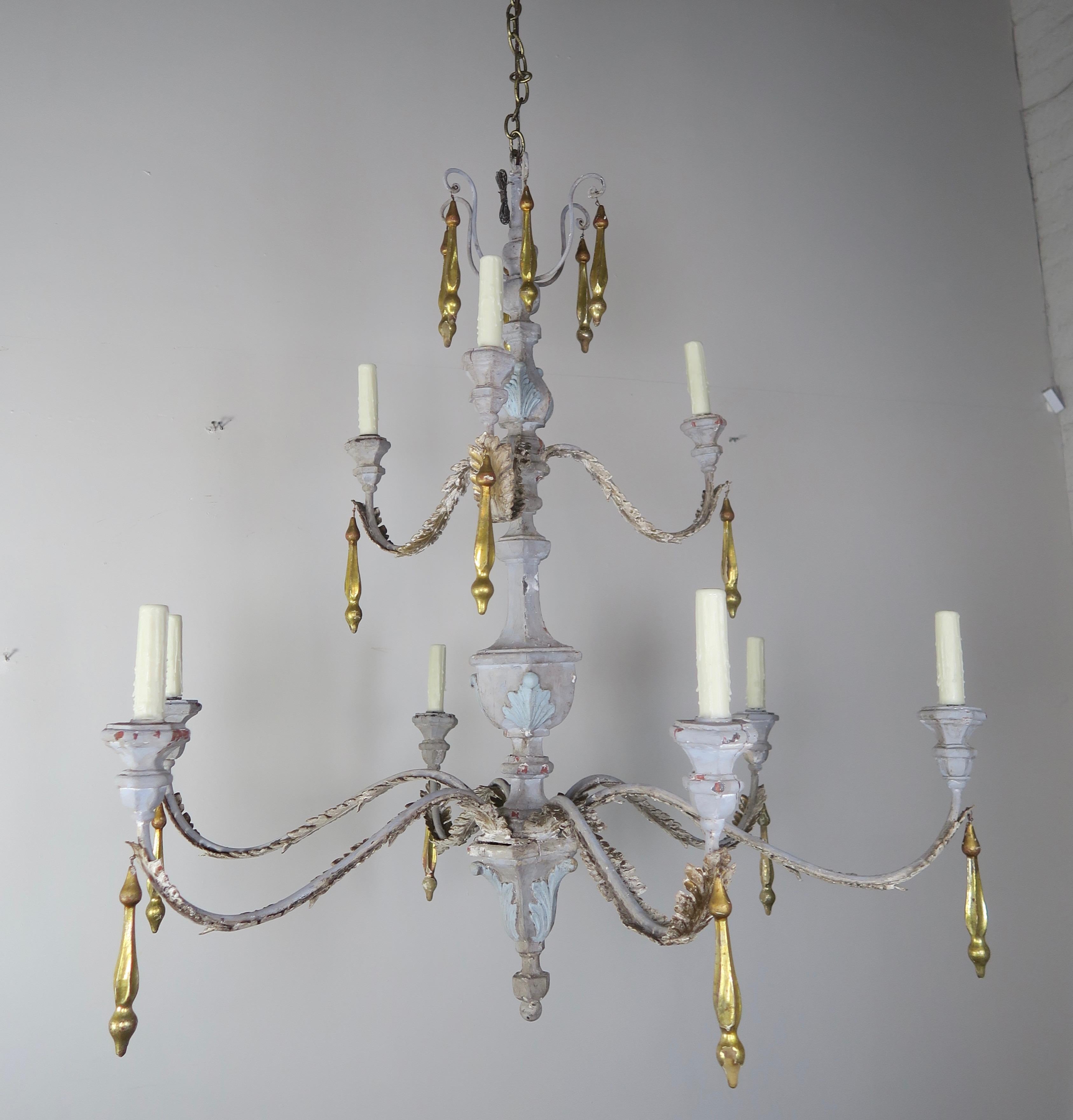 (10) light Italian painted and parcel gilt two-tier chandelier with gold leaf tassels hanging throughout. The fixture is painted in a beautiful dove gray coloration with soft bluish accents on the raised carvings. Iron acanthus leaves adorn the arms